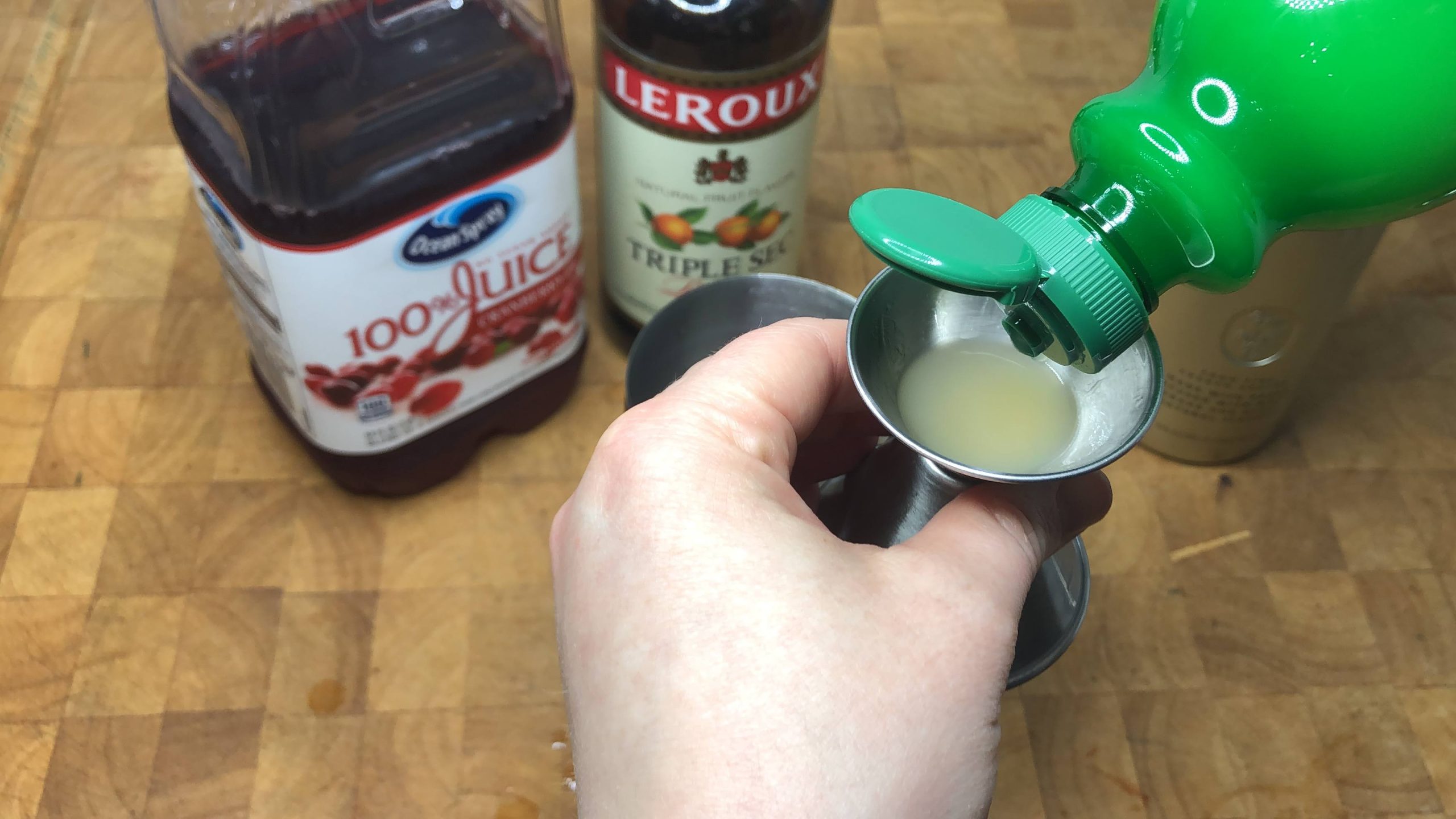 filling jigger with lime juice