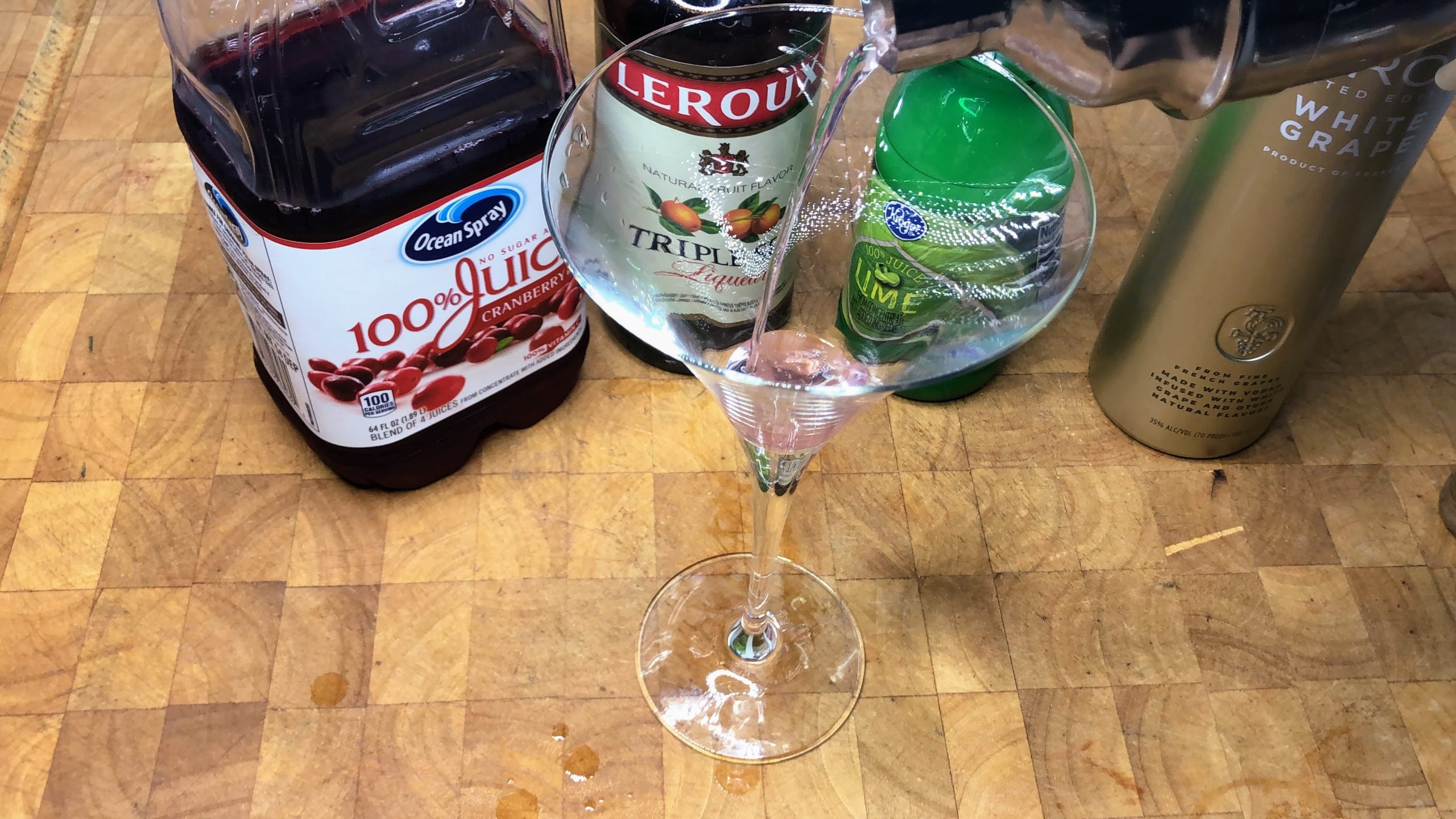 pouring grape cosmo from shaker into glass
