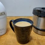 rumchata coffee in a mug with coffee pot and rumchata next to the drink