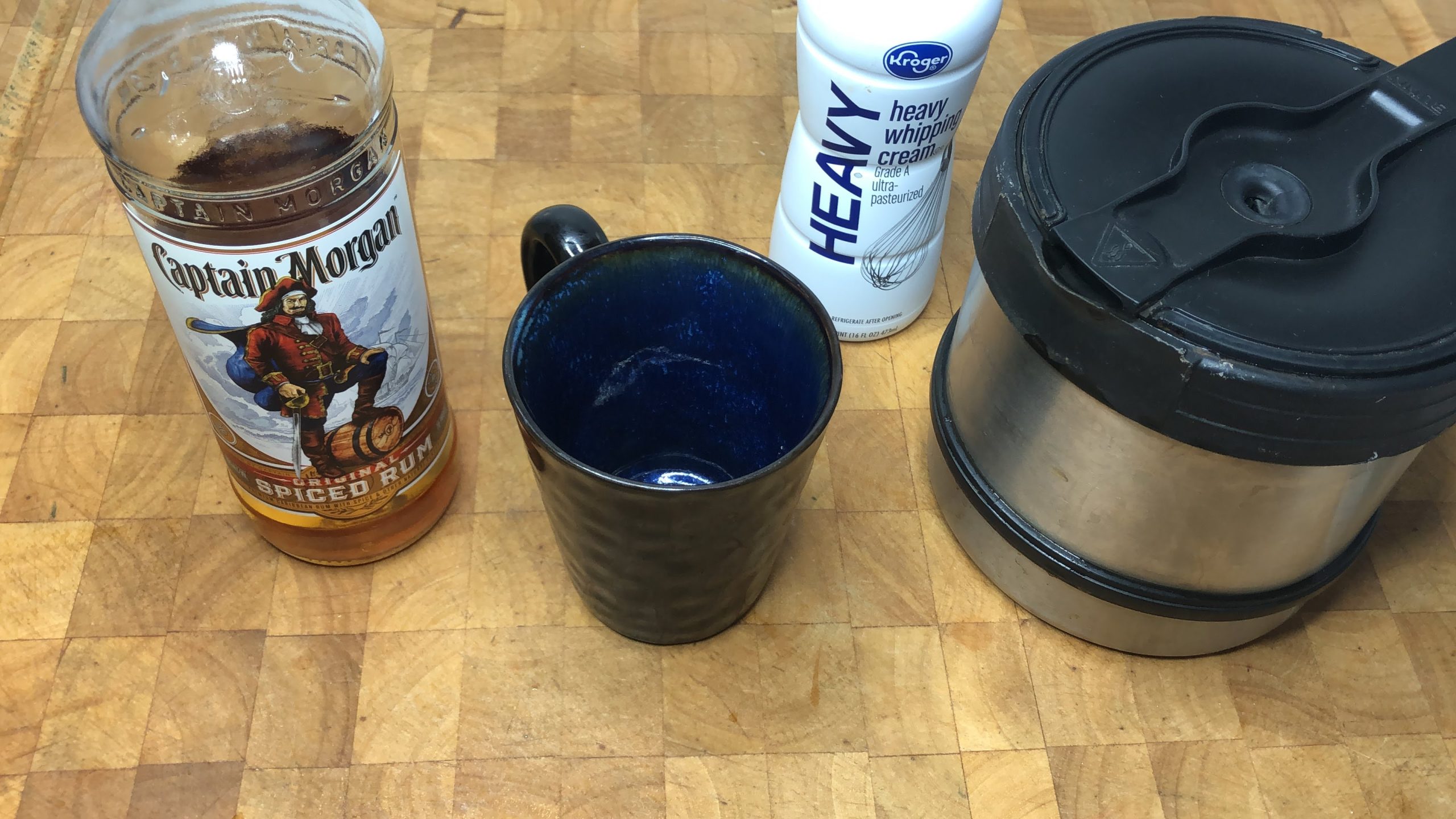 coffee mug next to coffee pot, heavy cream and spiced rum