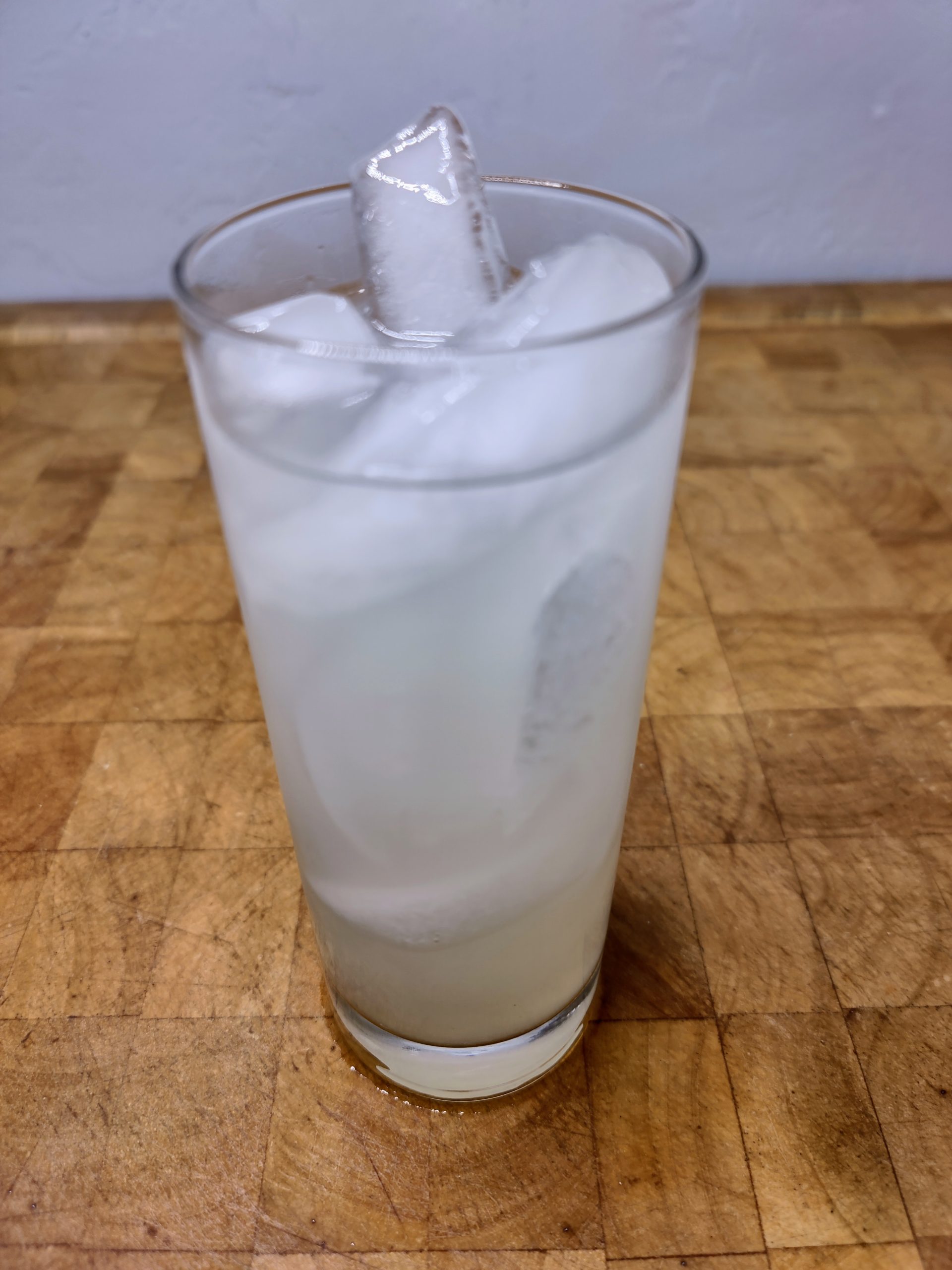 vodka cherry limeade in a highball glass on a wooden table