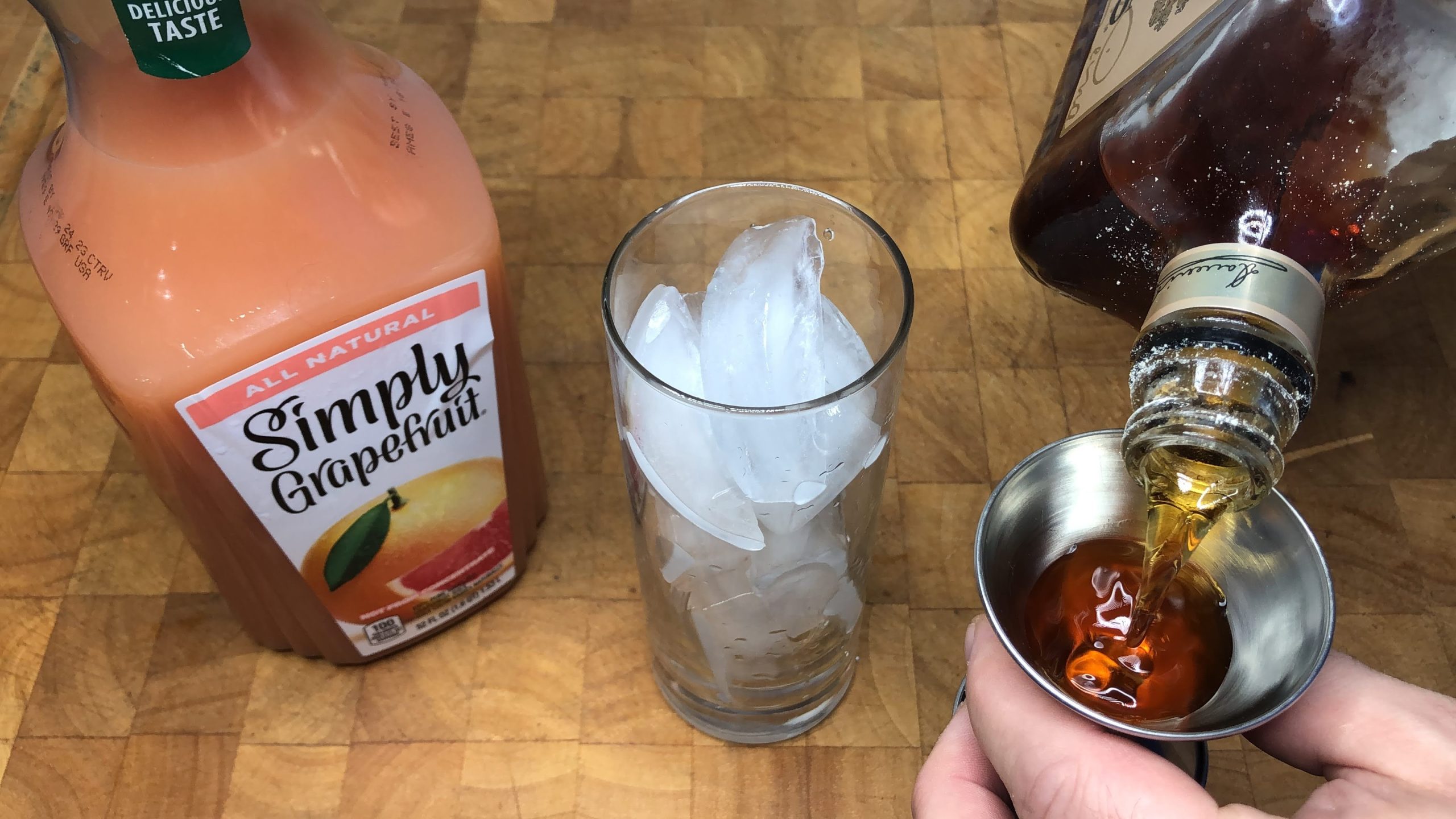 measuring amaretto with a jigger