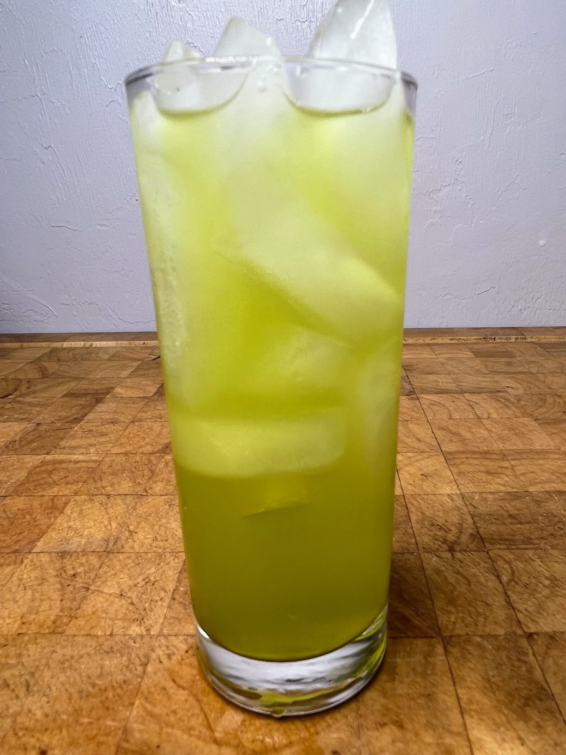closeup of cactus juice cocktail in a highball glass on a wooden table