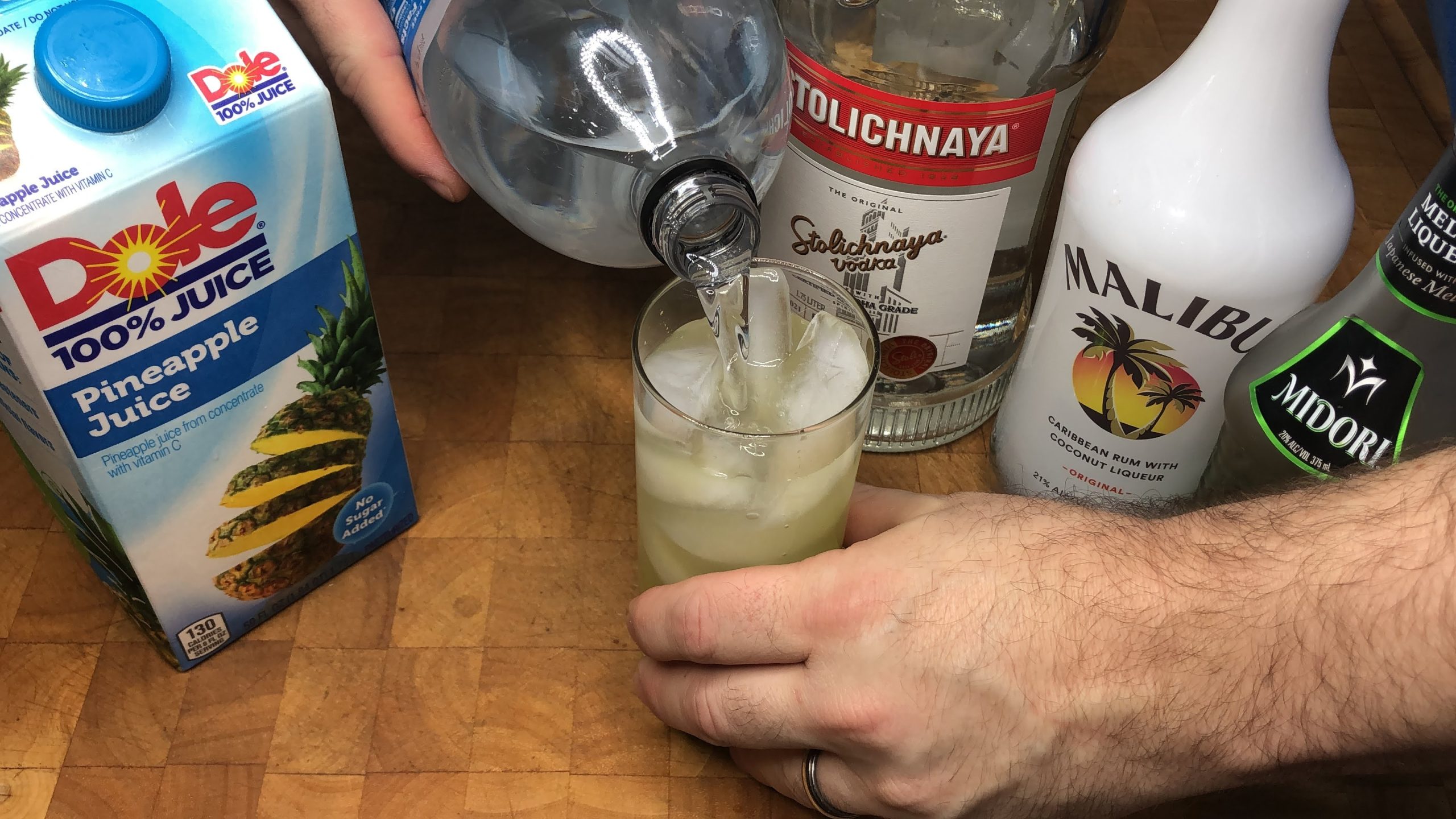 pouring club soda into highball glass