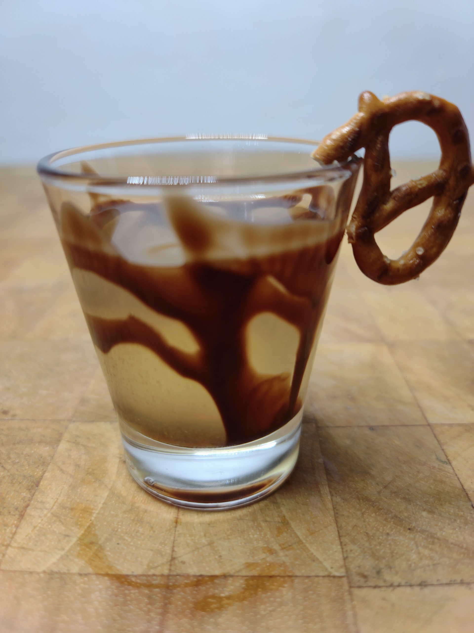 closeup of chocolate covered pretzel shot on a wooden table
