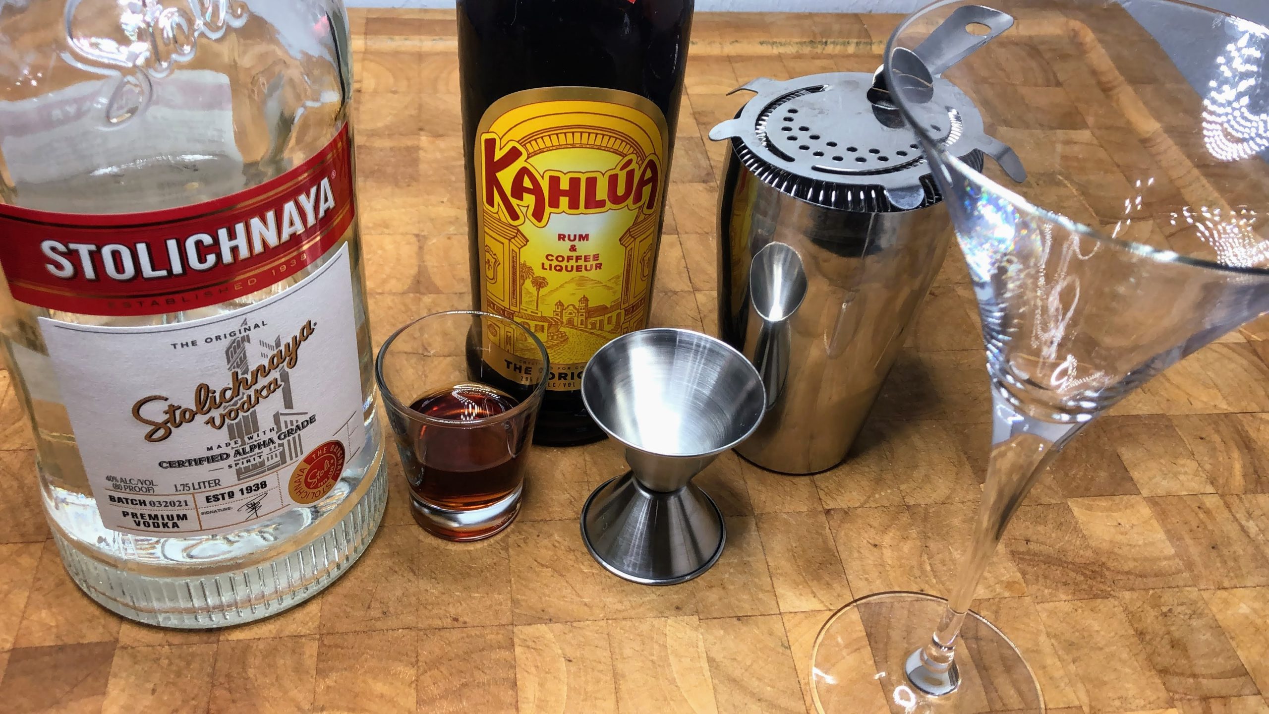 martini glass next to shaker, jigger, cold brew, vodka and kahlua