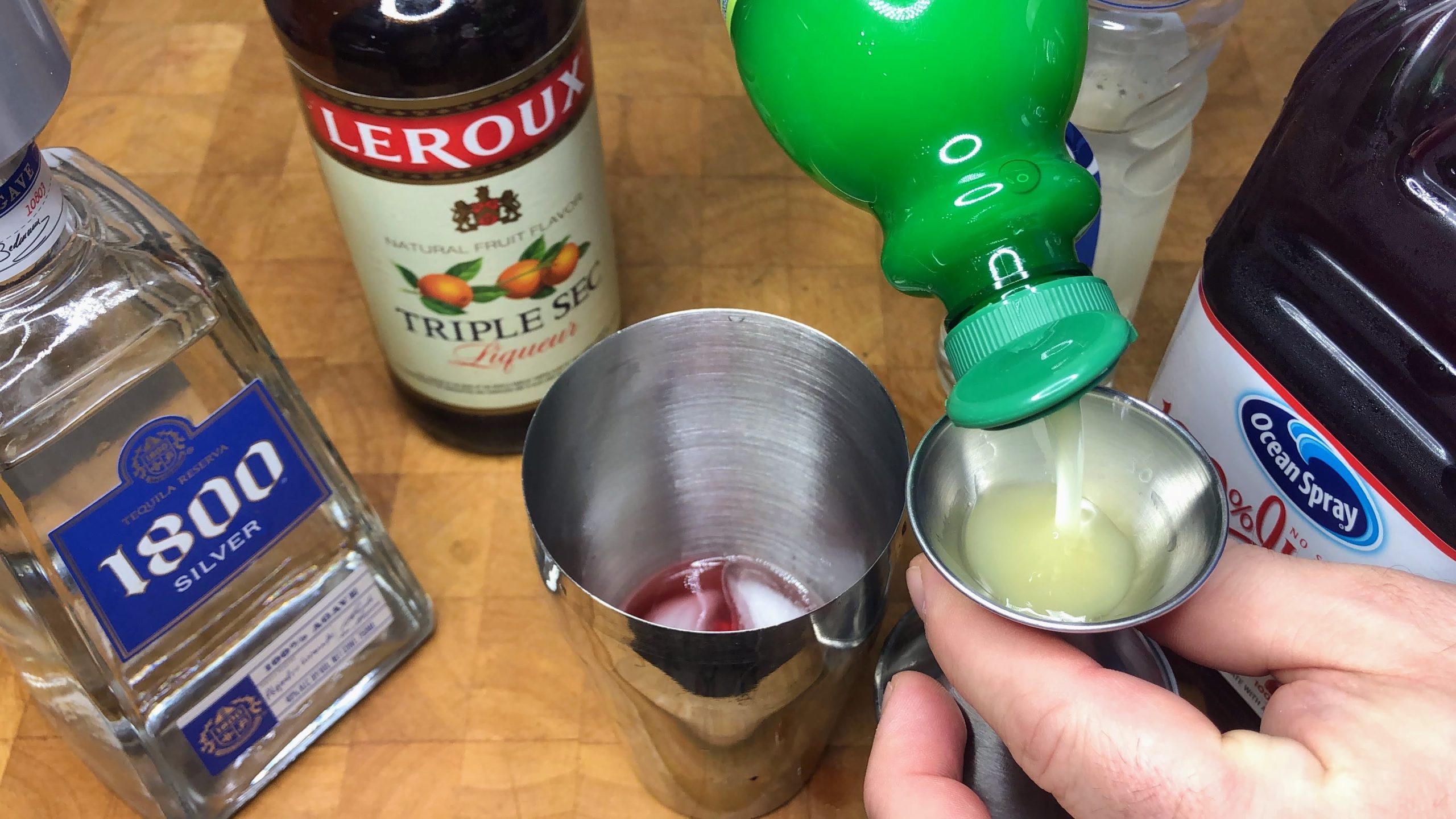 pouring lime juice in a jigger