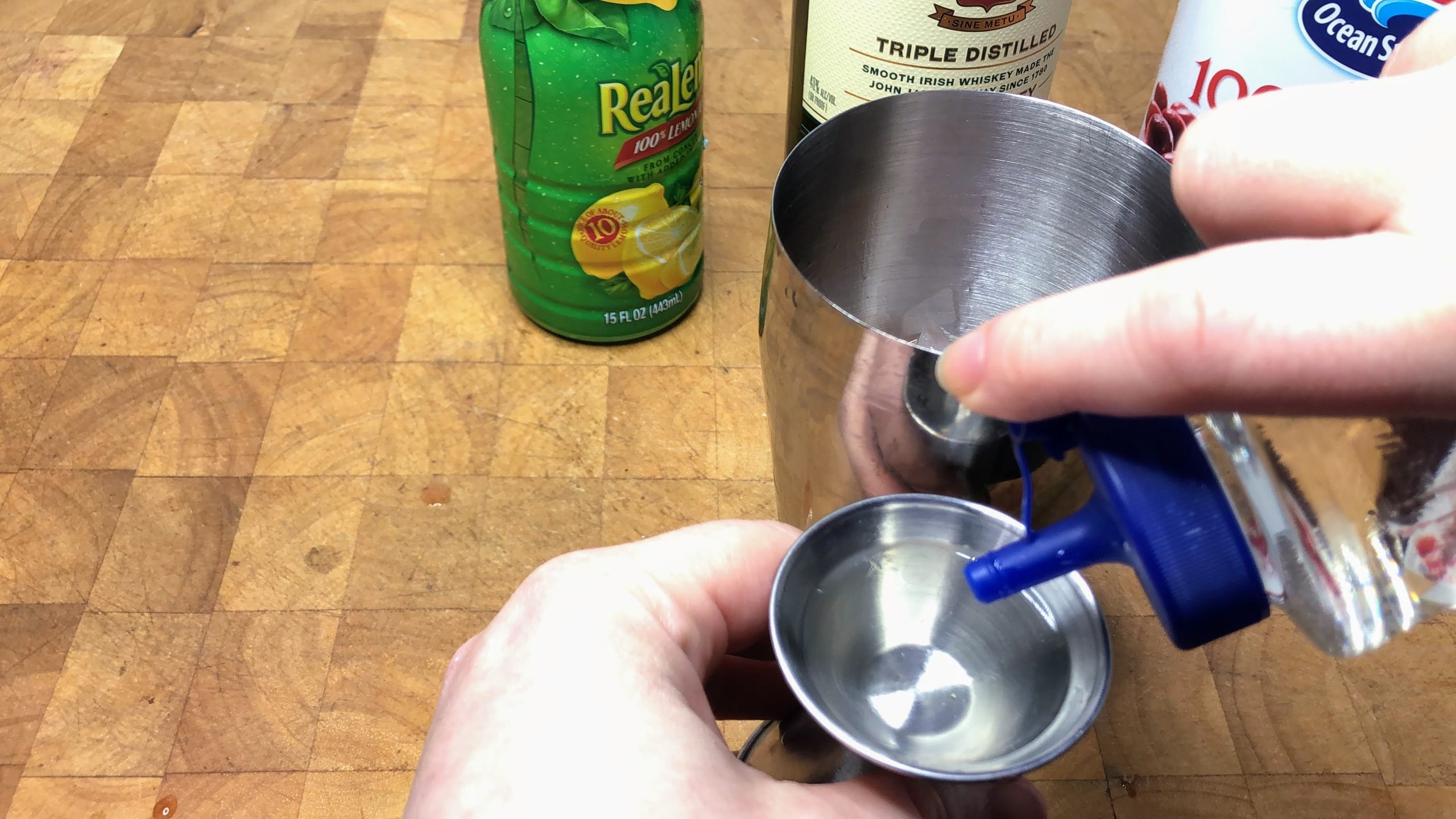 pouring simple syrup in a jigger