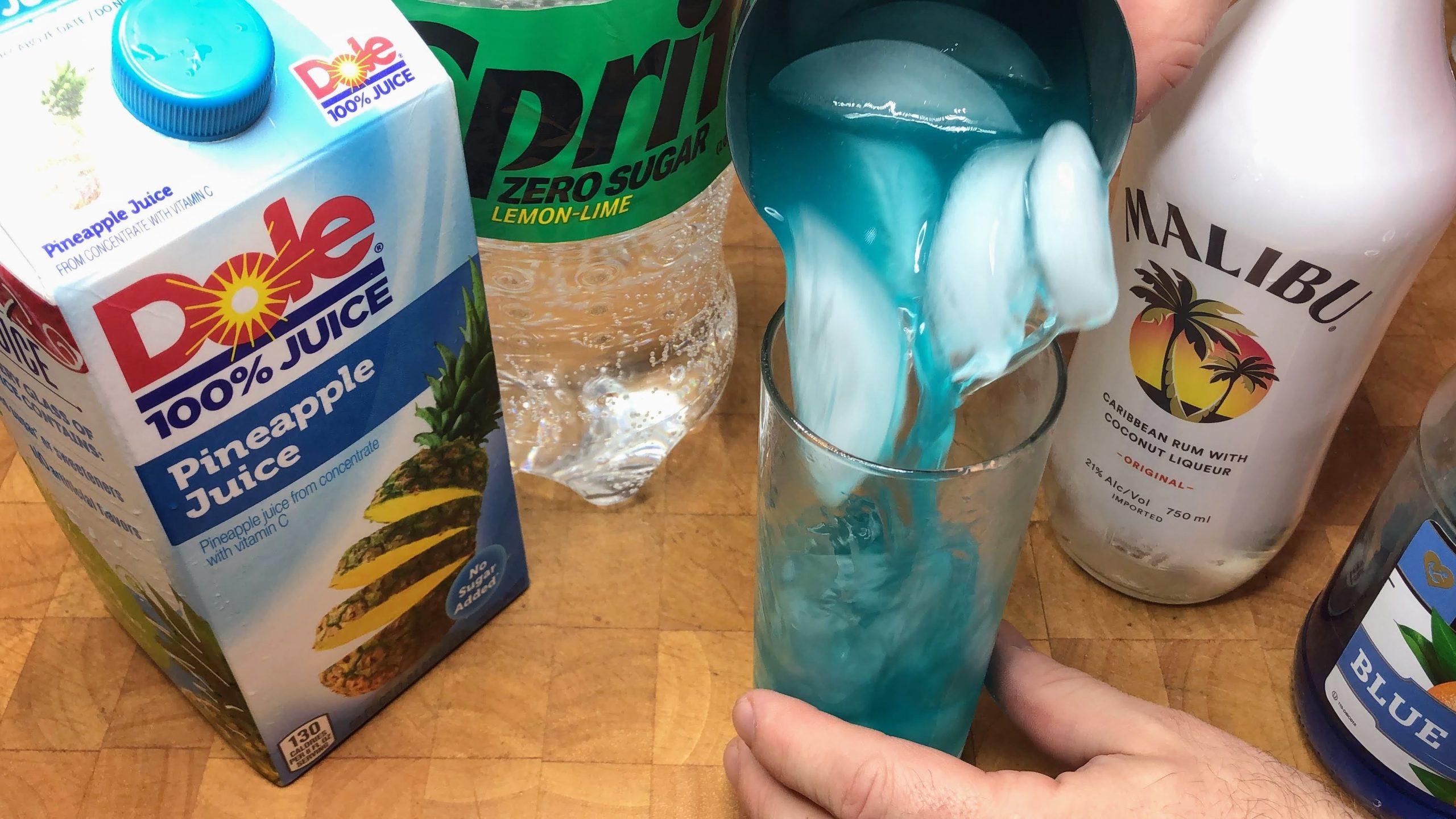 pouring electric smurf drink from shaker into glass