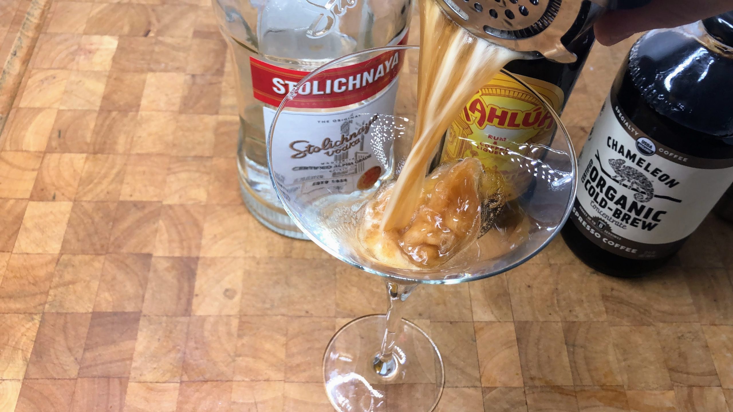 pouring espresso martini from shaker into glass