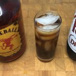 fireball and dr pepper in a highball glass with ingredient bottles next to the glass
