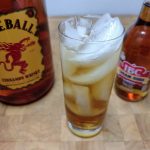 fireball and cream soda in a highball glass with ingredient bottles next to the glass