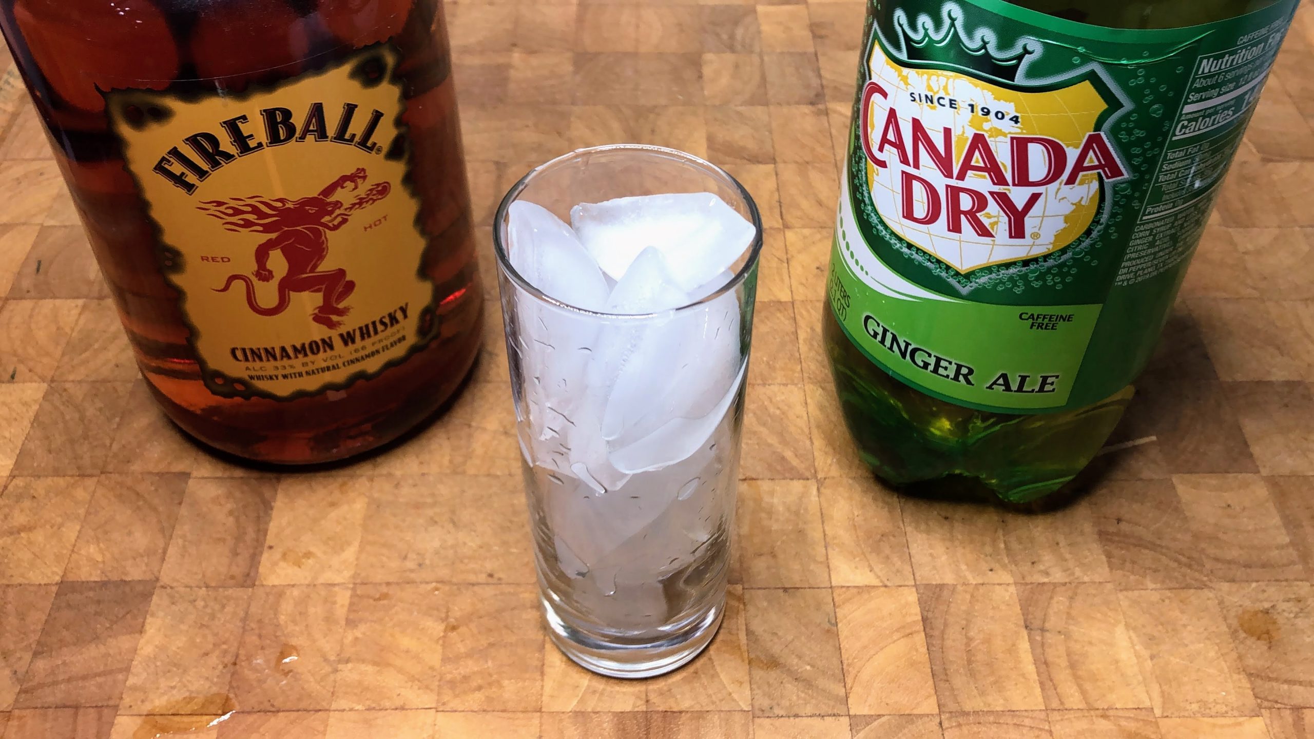 bottles of ginger ale, fireball and a glass filled with ice