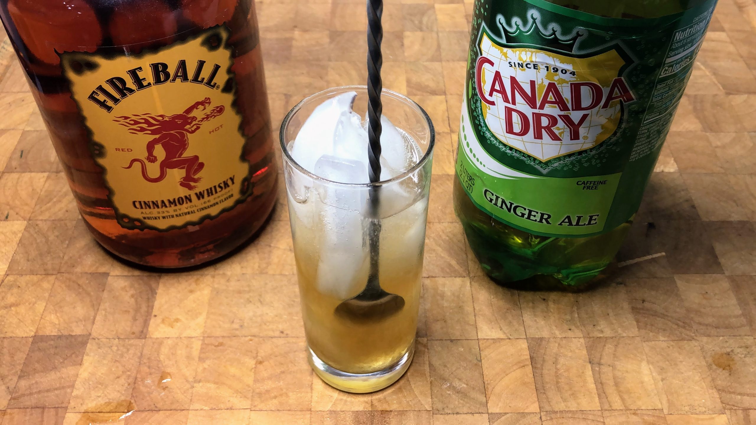 using a bar spoon to stir fireball and ginger ale