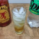 fireball and sprite in a highball glass with ingredient bottles next to the glass
