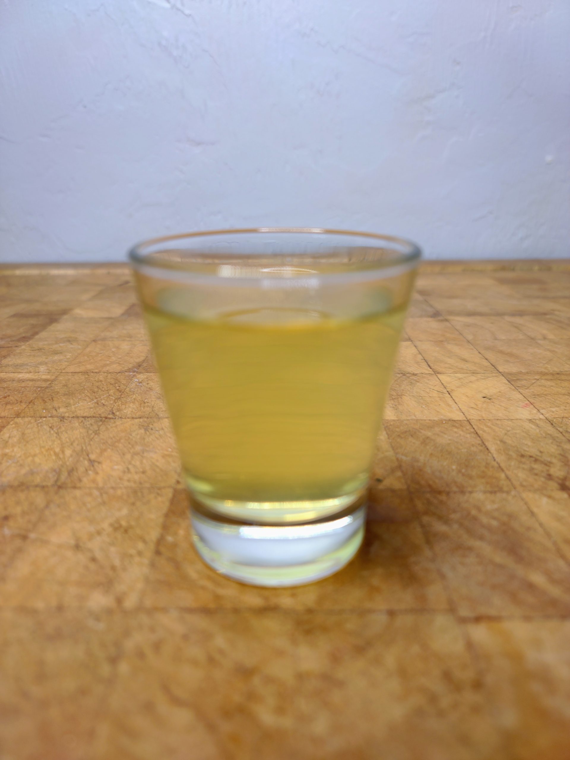 closeup of a green tea shot on a wooden table