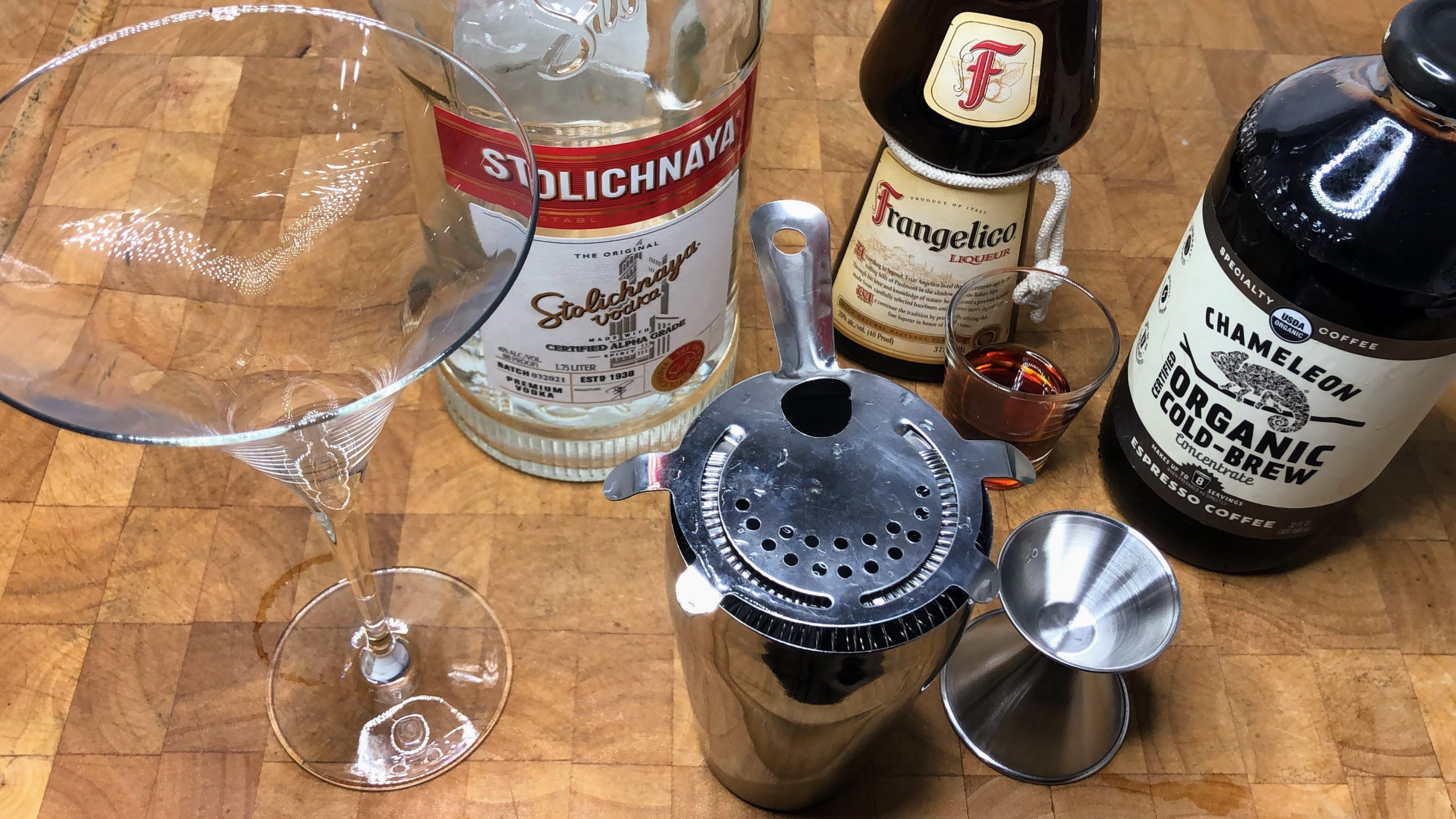 martini glass next to shaker, jigger, espresso, frangelico and vodka