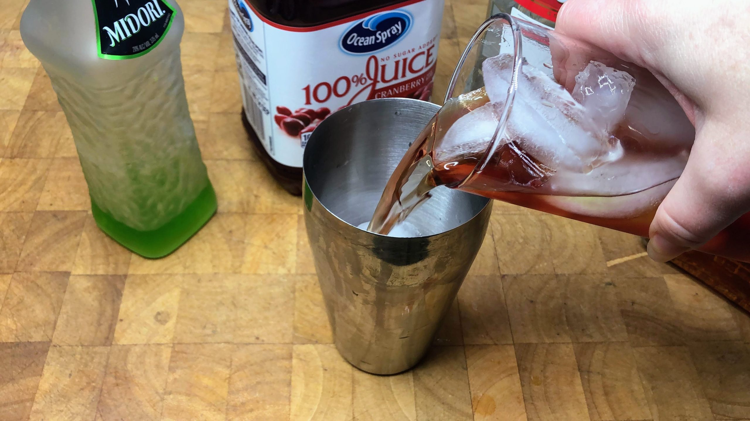 pouring killer koolaid from glass into shaker