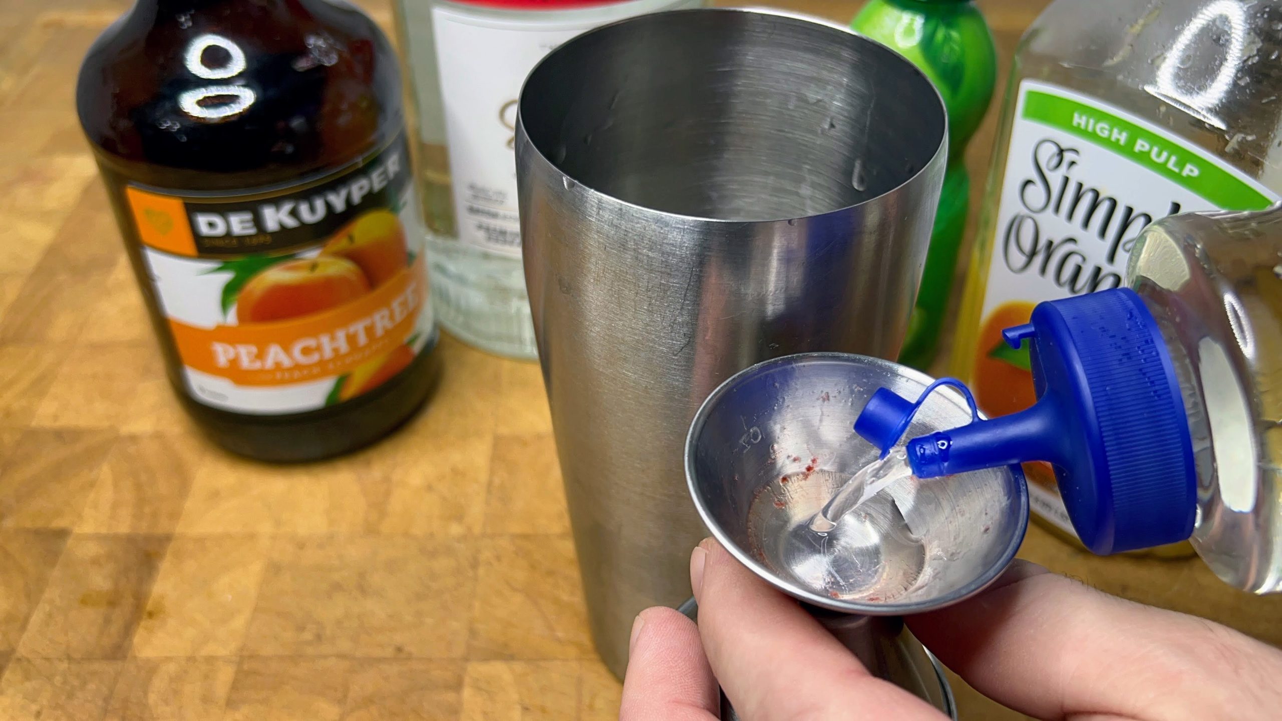measuring simple syrup with jigger