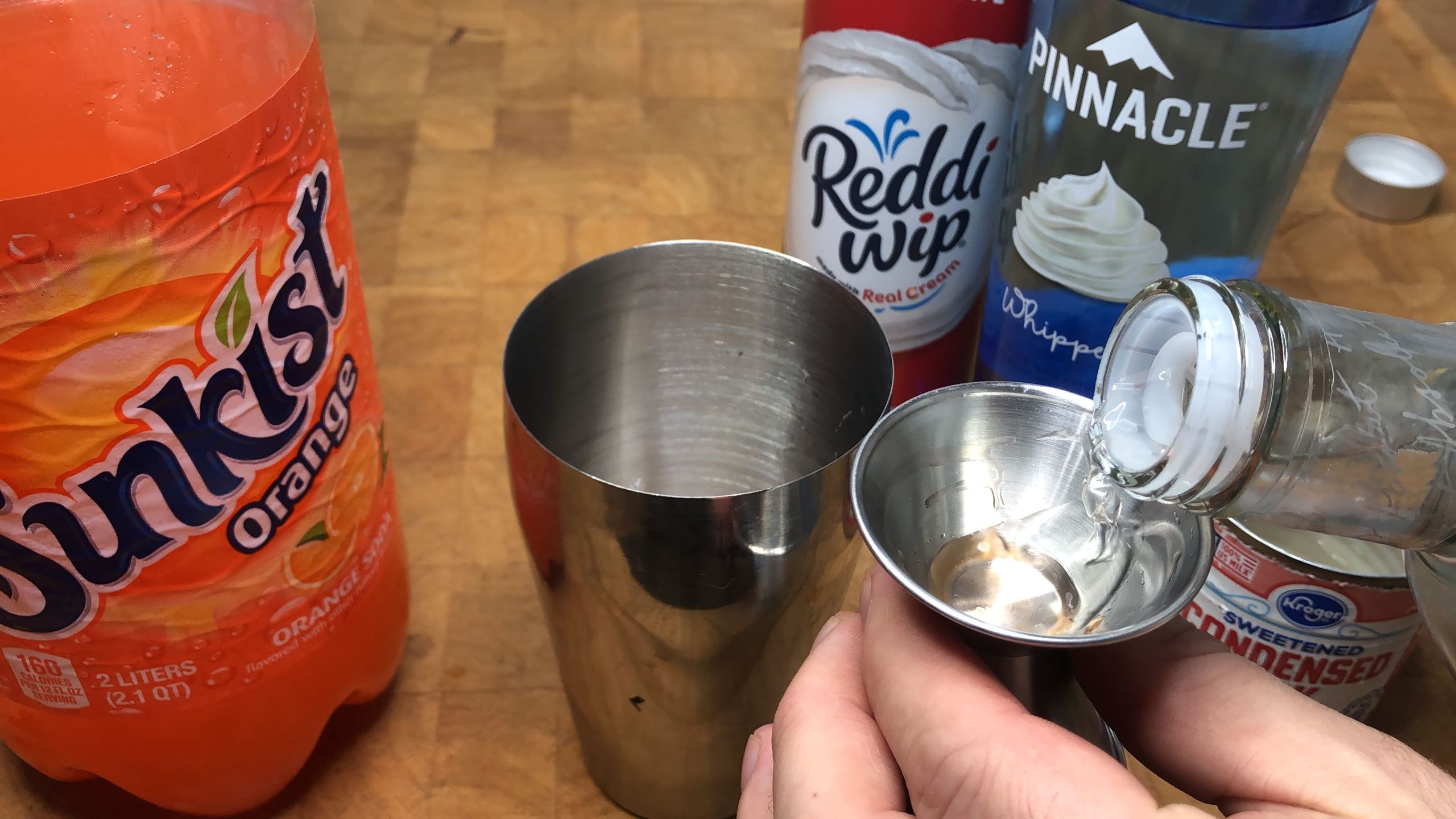 pouring orange vodka in jigger