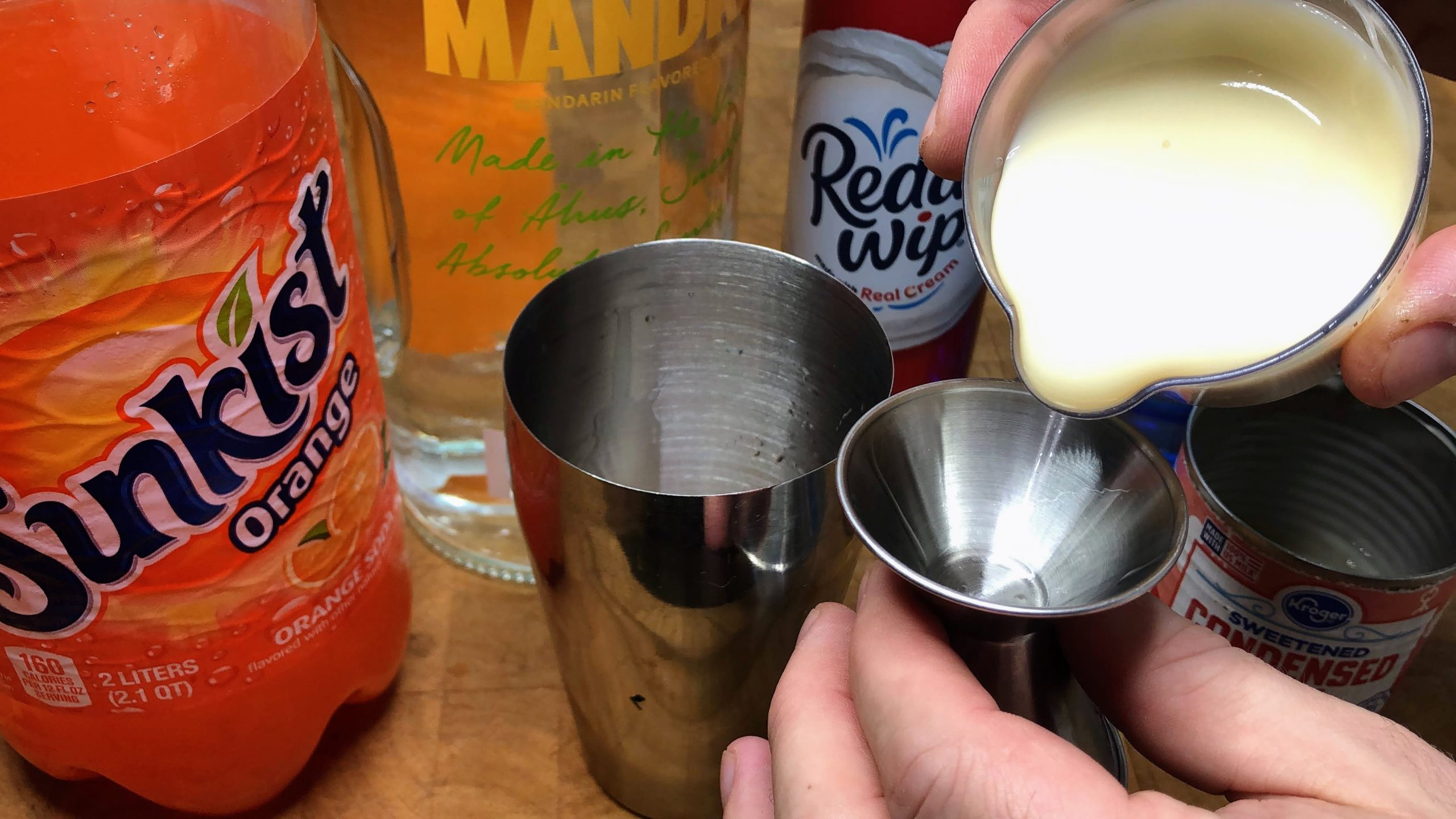 pouring sweetened condensed milk in a jigger