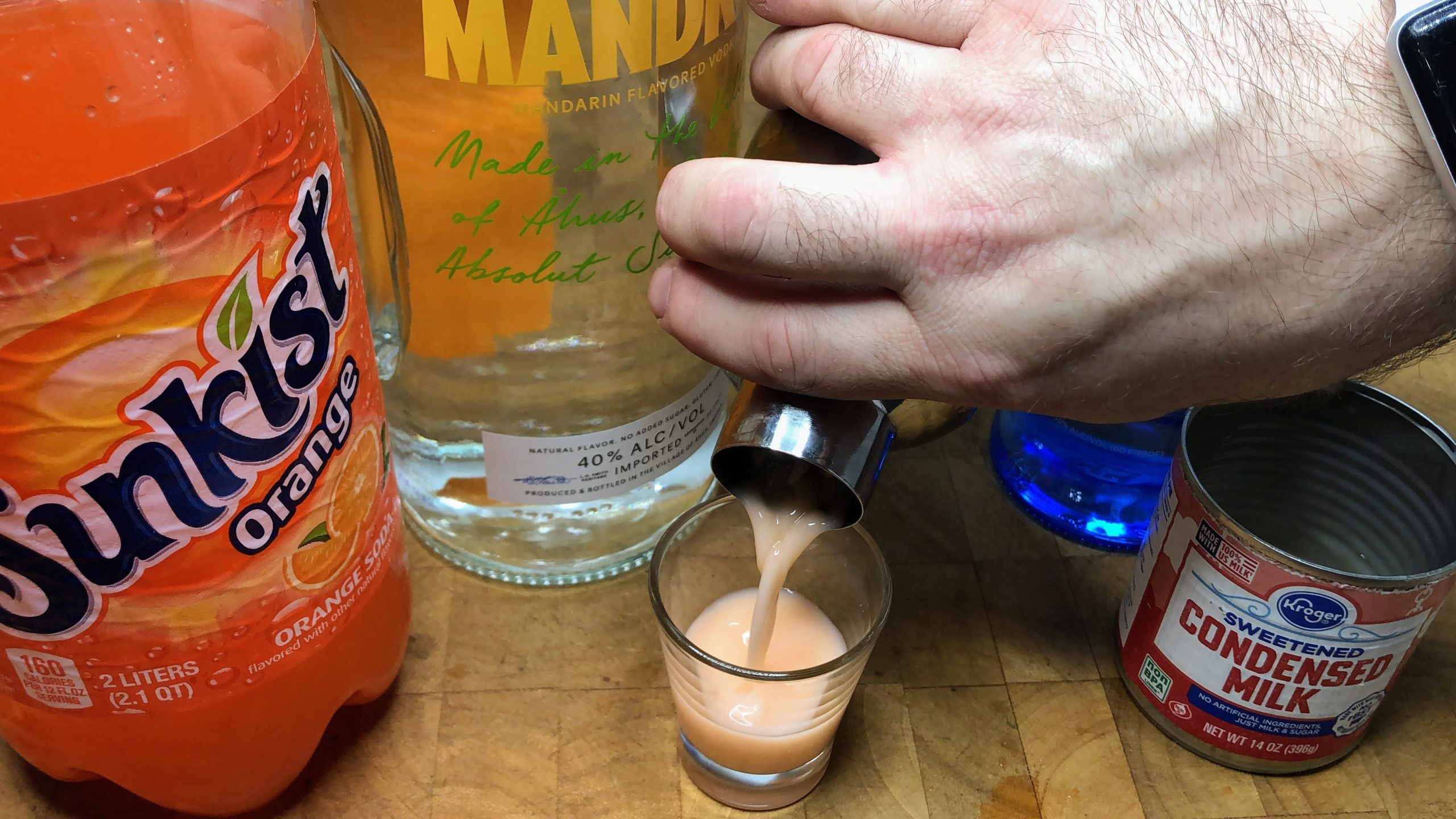 pouring orange creamsicle shot into glass