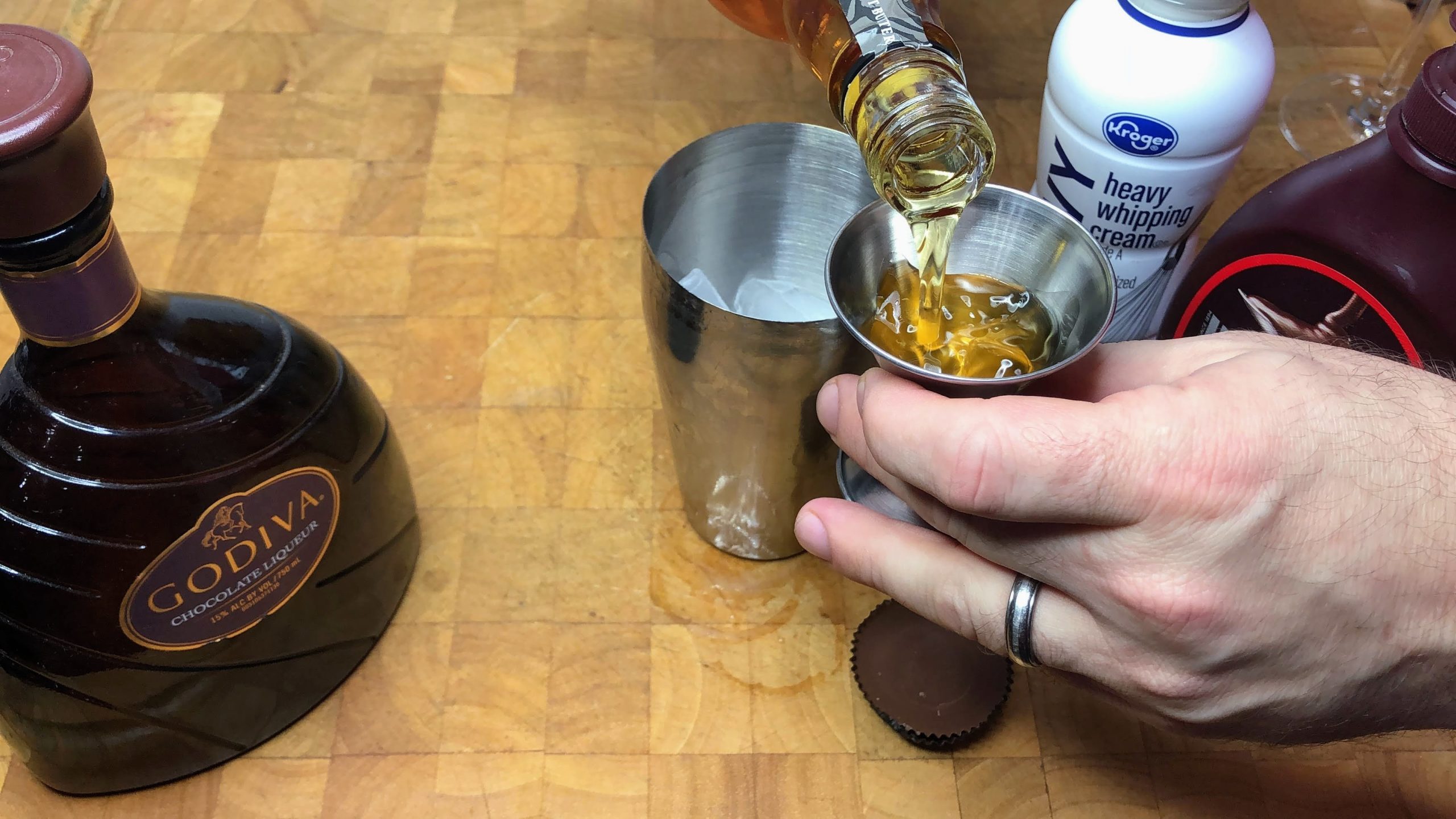 measuring peanut butter whiskey with a jigger