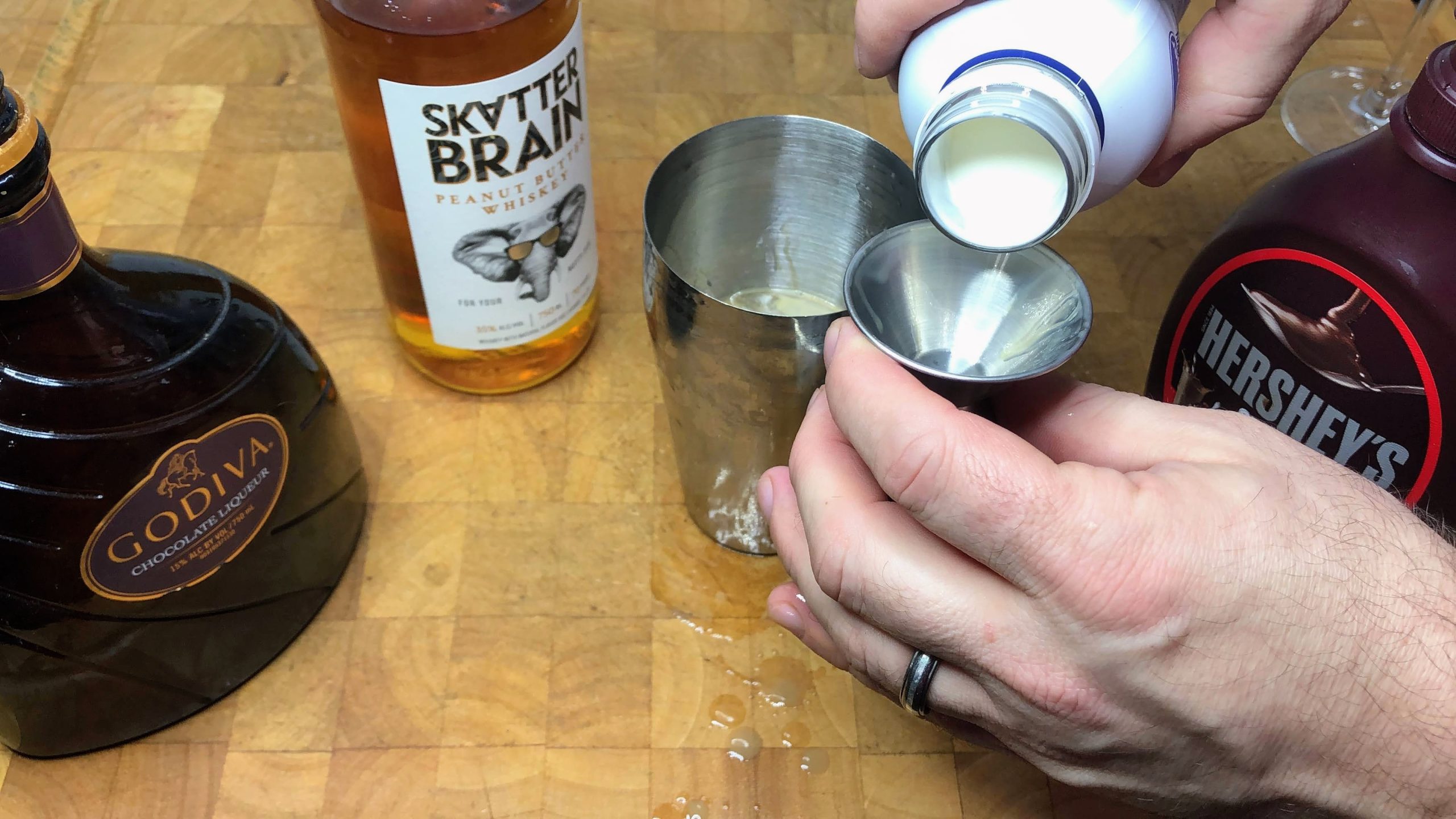 measuring heavy cream in a jigger
