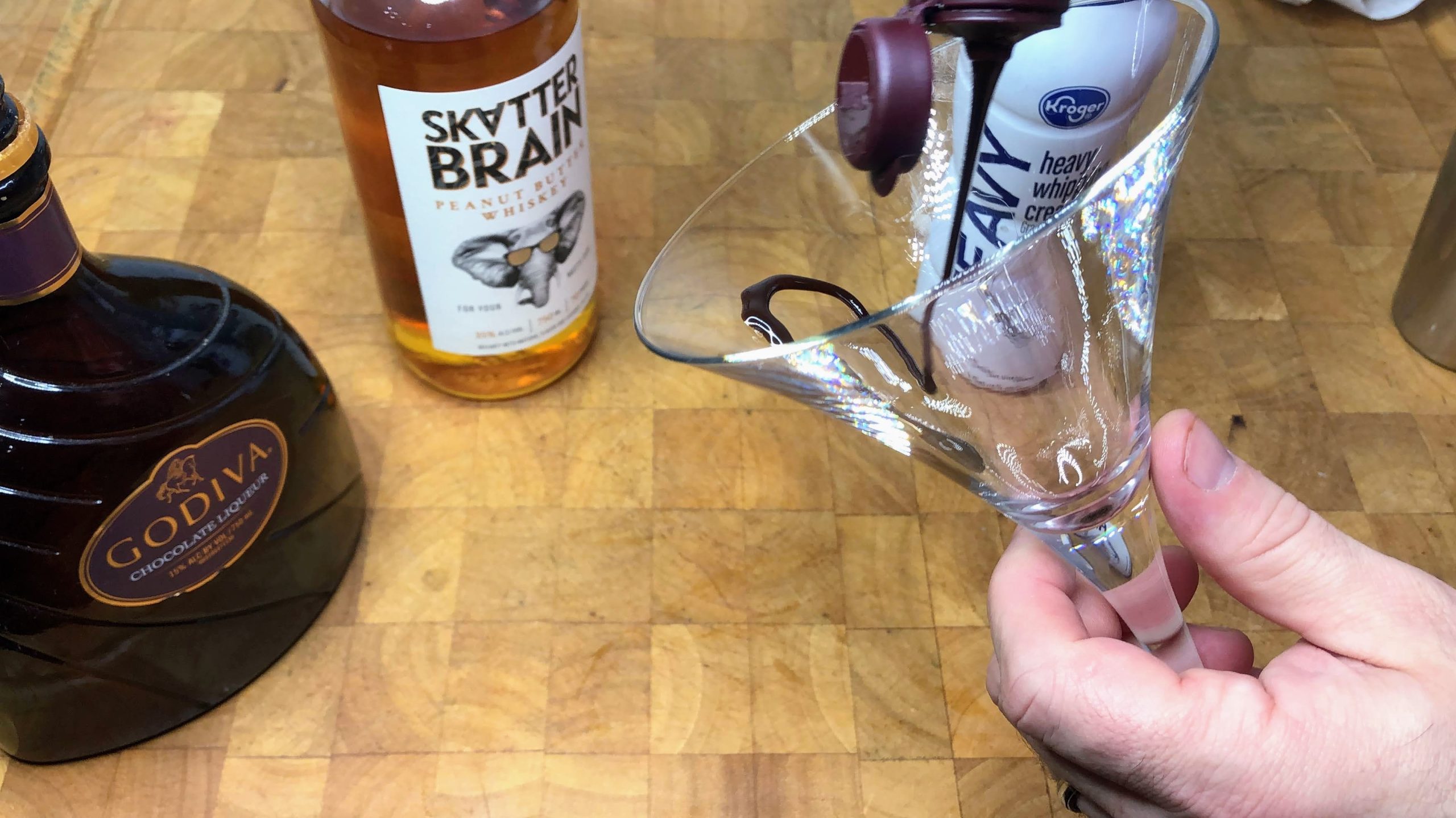 drizzling chocolate syrup inside a martini glass