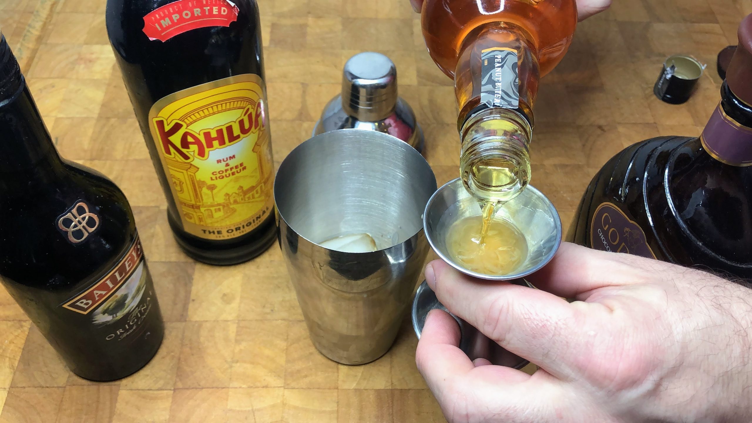 pouring peanut butter whiskey in a jigger