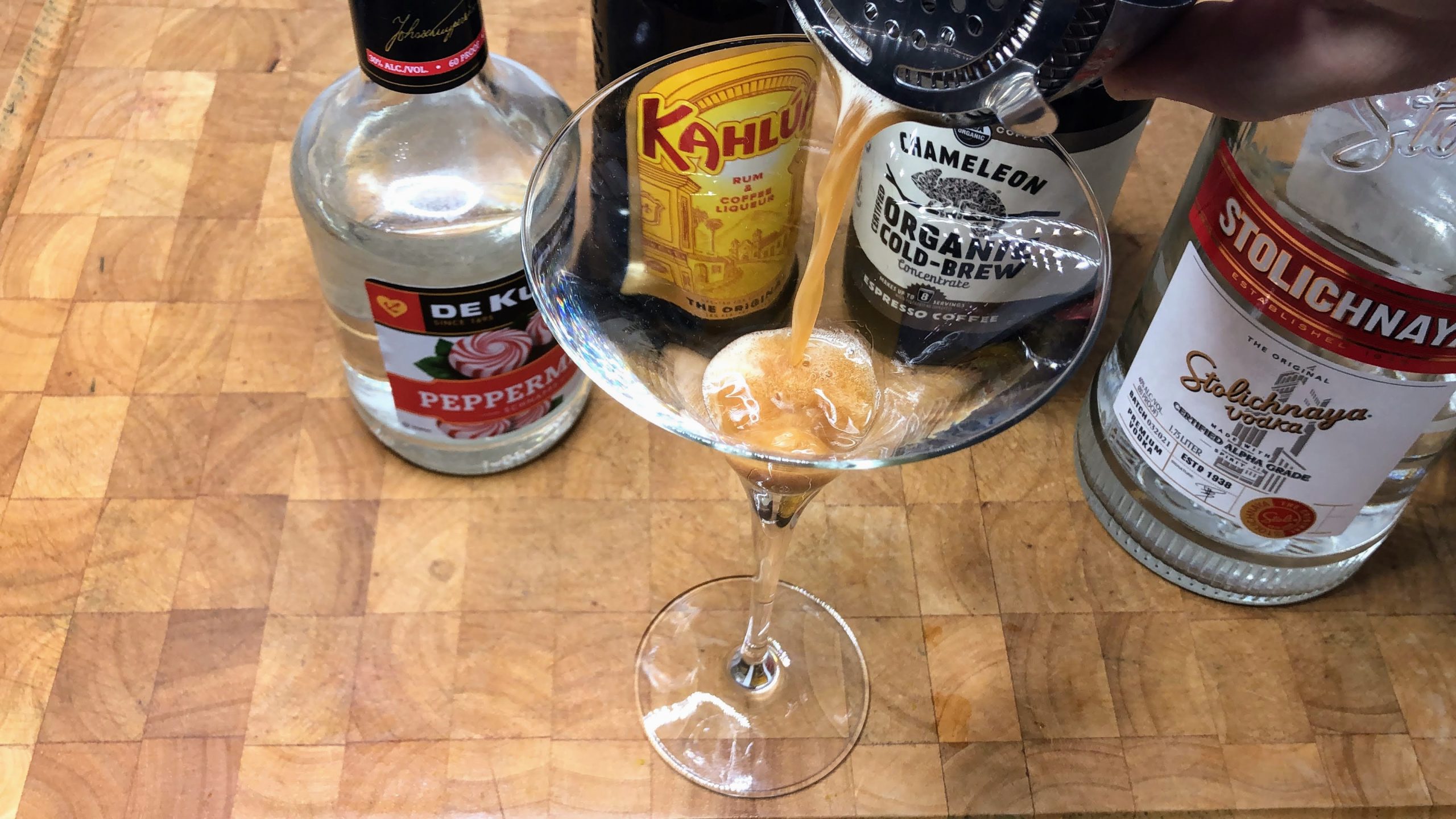 pouring peppermint espresso martini from shaker into glass