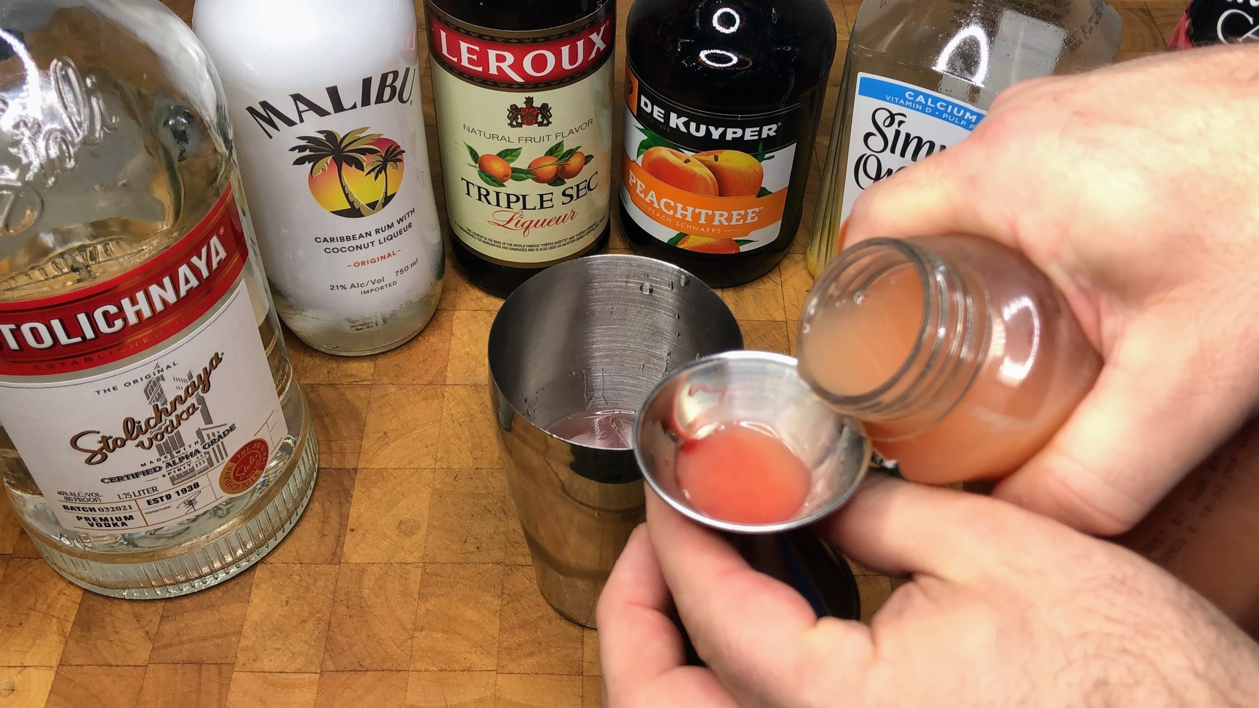 measuring grapefruit juice with jigger