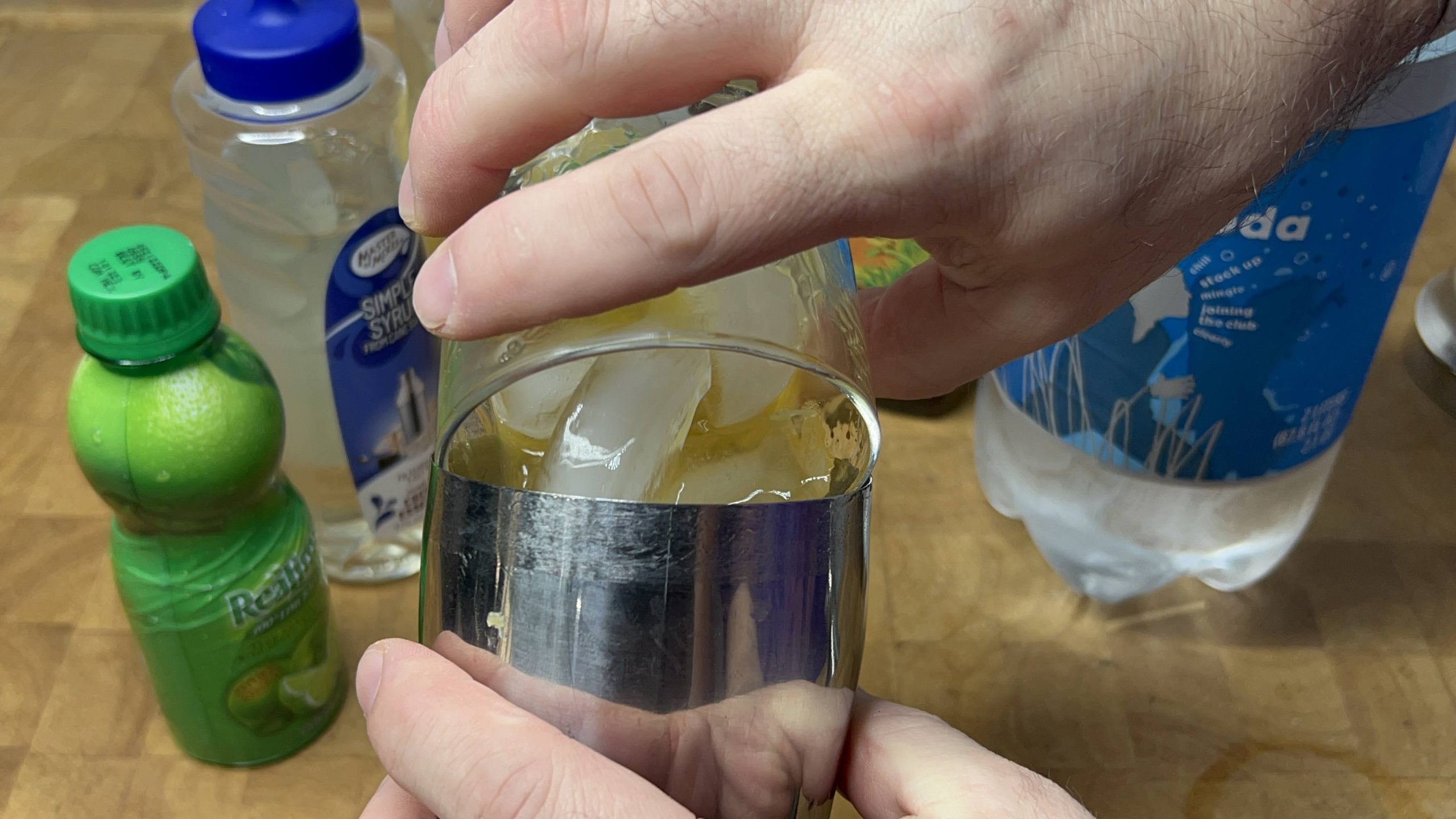 pouring planters punch into a cocktail shaker