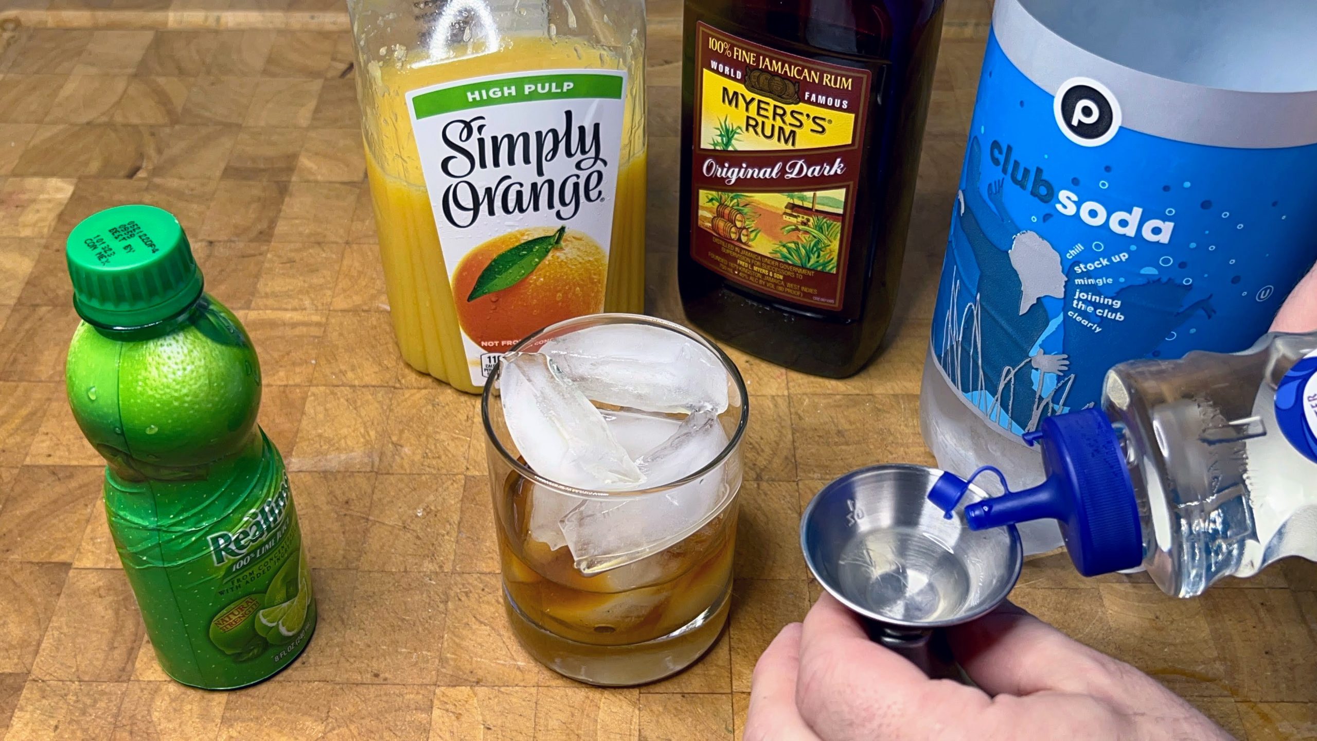 measuring simple syrup in a jigger