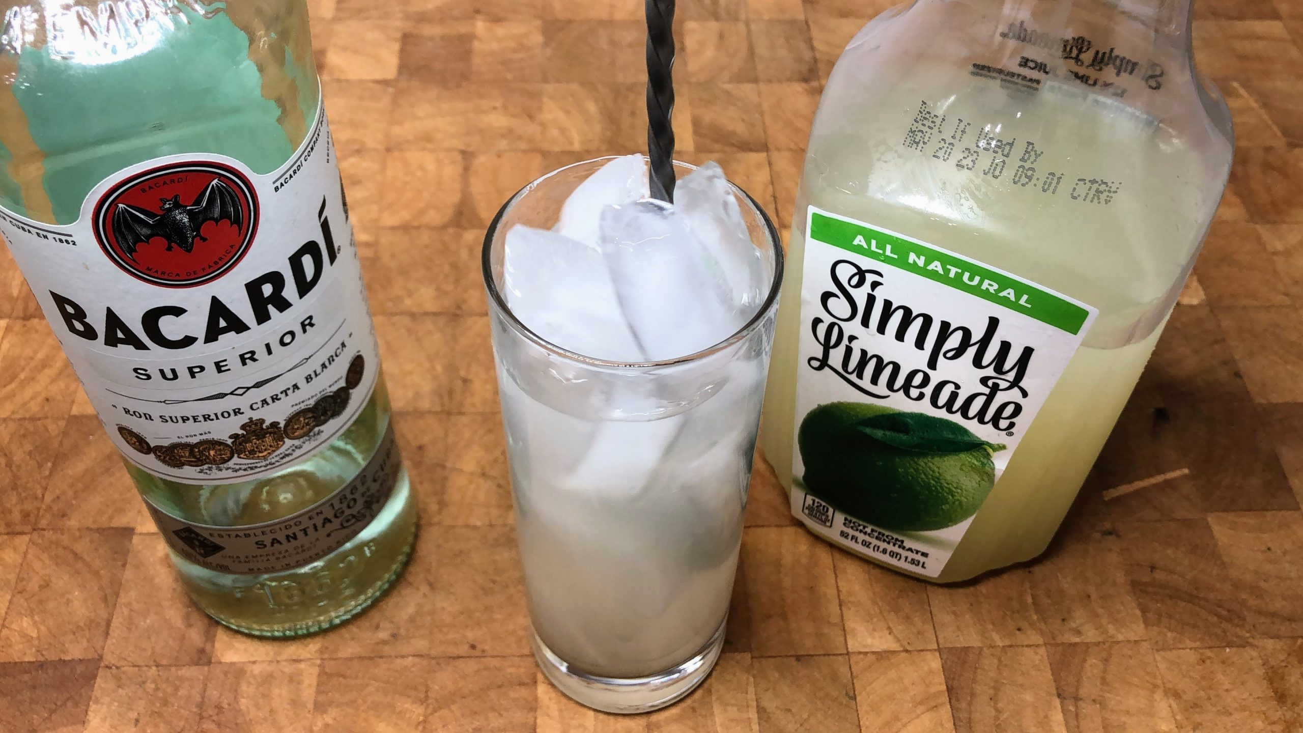 stirring rum and limeade with a bar spoon