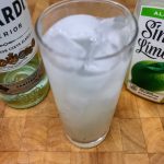 rum and limeade in a highball glass with ingredients next to the glass