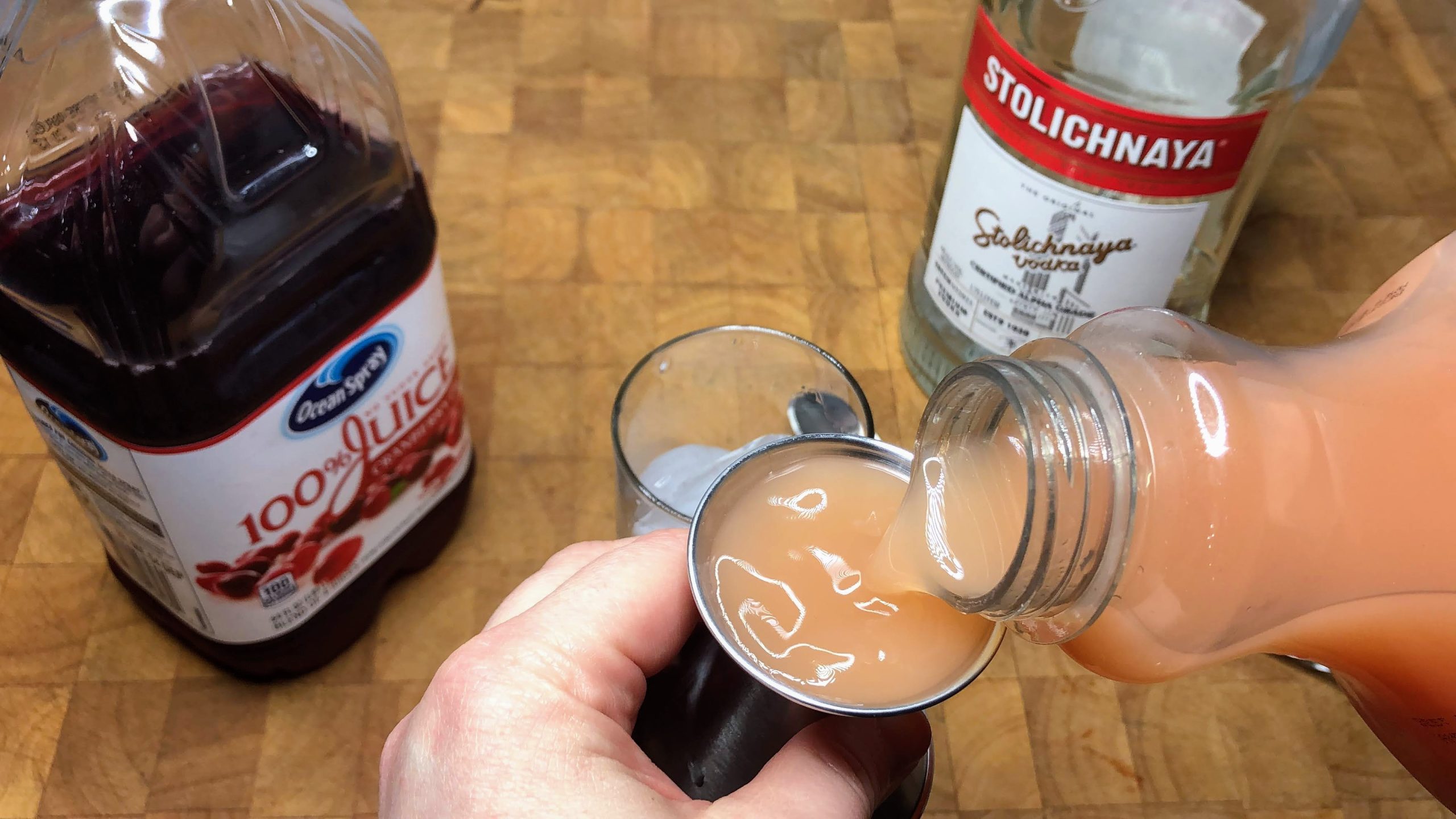using a jigger to pour grapefruit juice in