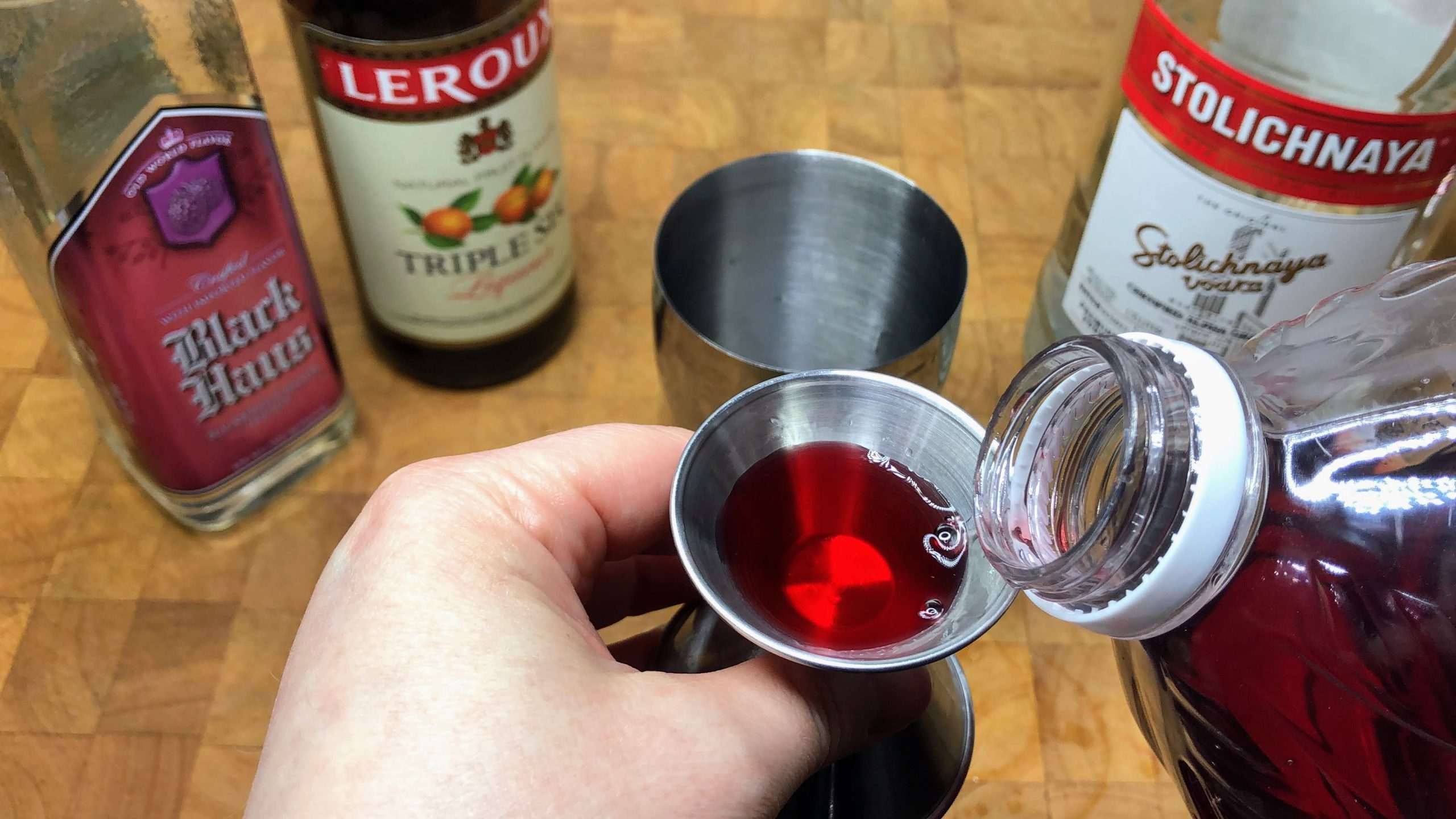 pouring cranberry juice in a jigger