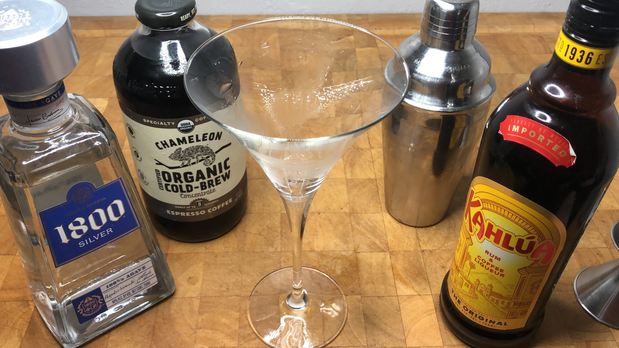 empty martini glass next to jigger and bottles of tequla, espresso and kahlua