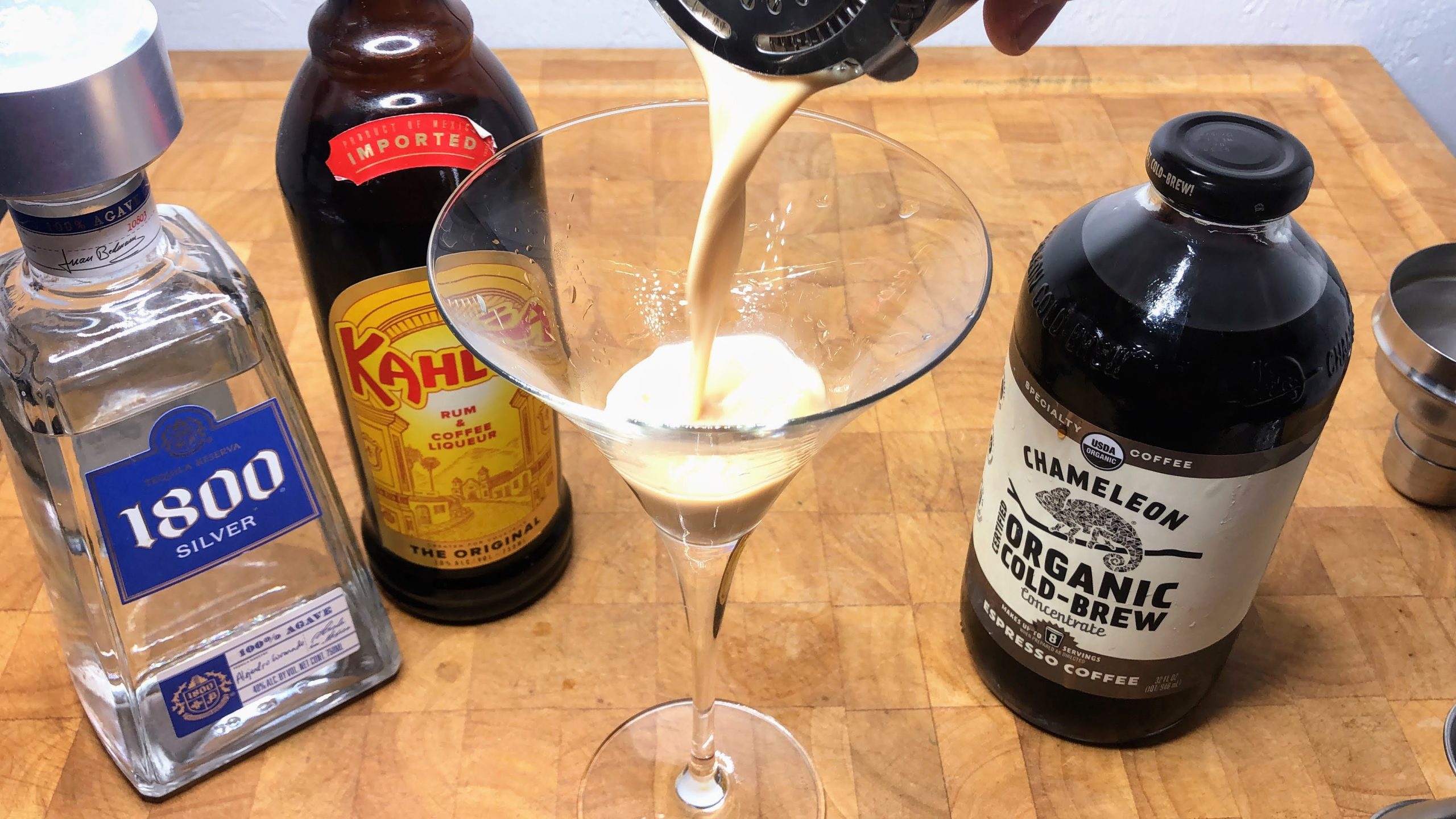 pouring tequila espresso martini from shaker into glass