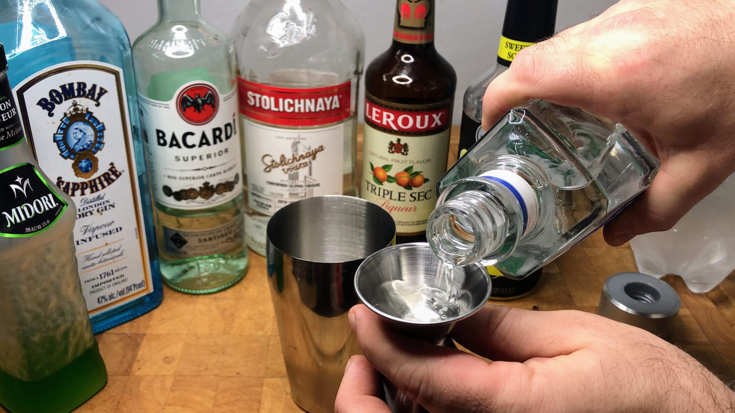 pouring silver tequila in a jigger