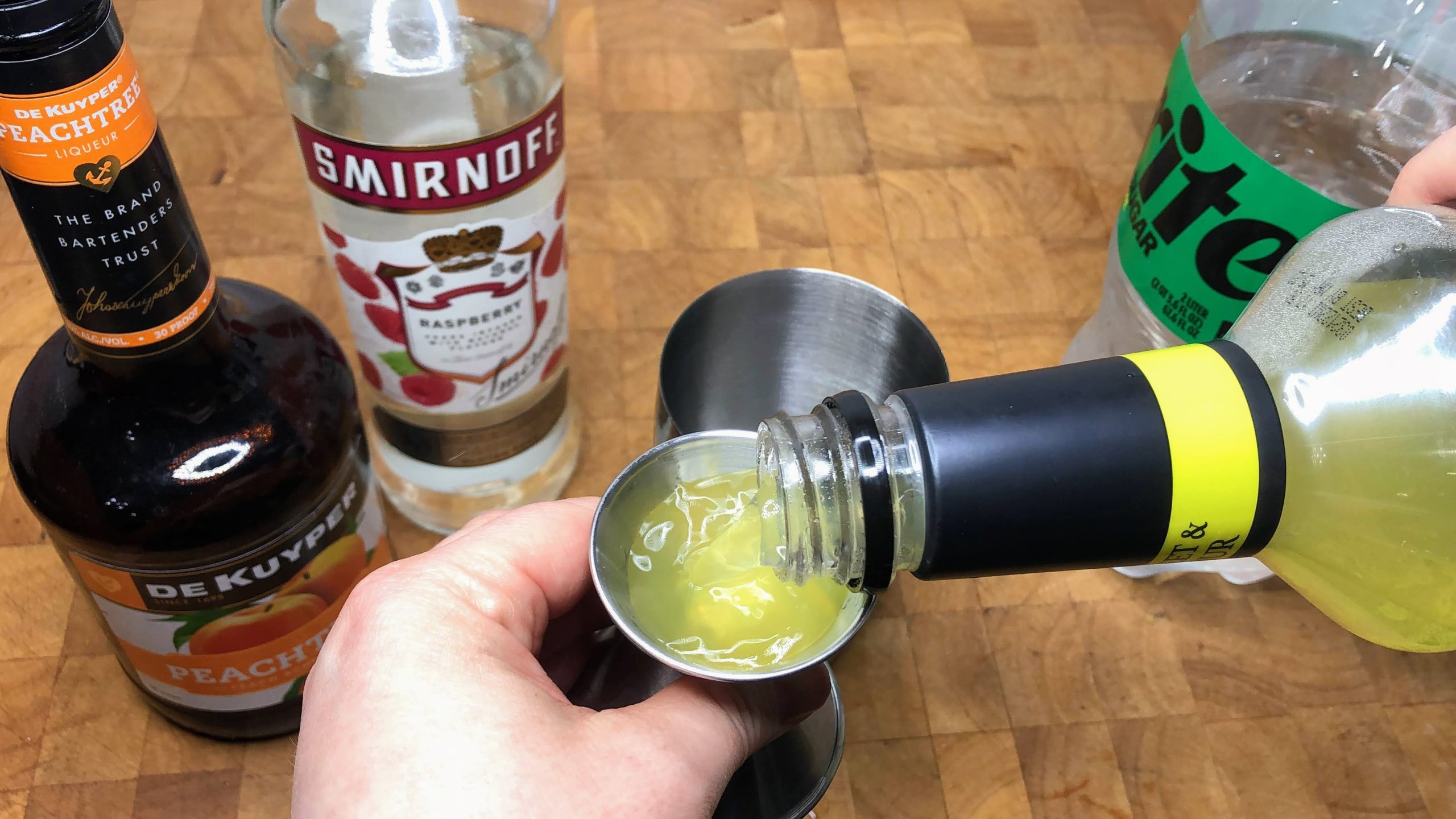 filling jigger with sour mix