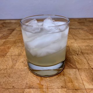 Foghorn drink in a rocks glass on a wooden table.