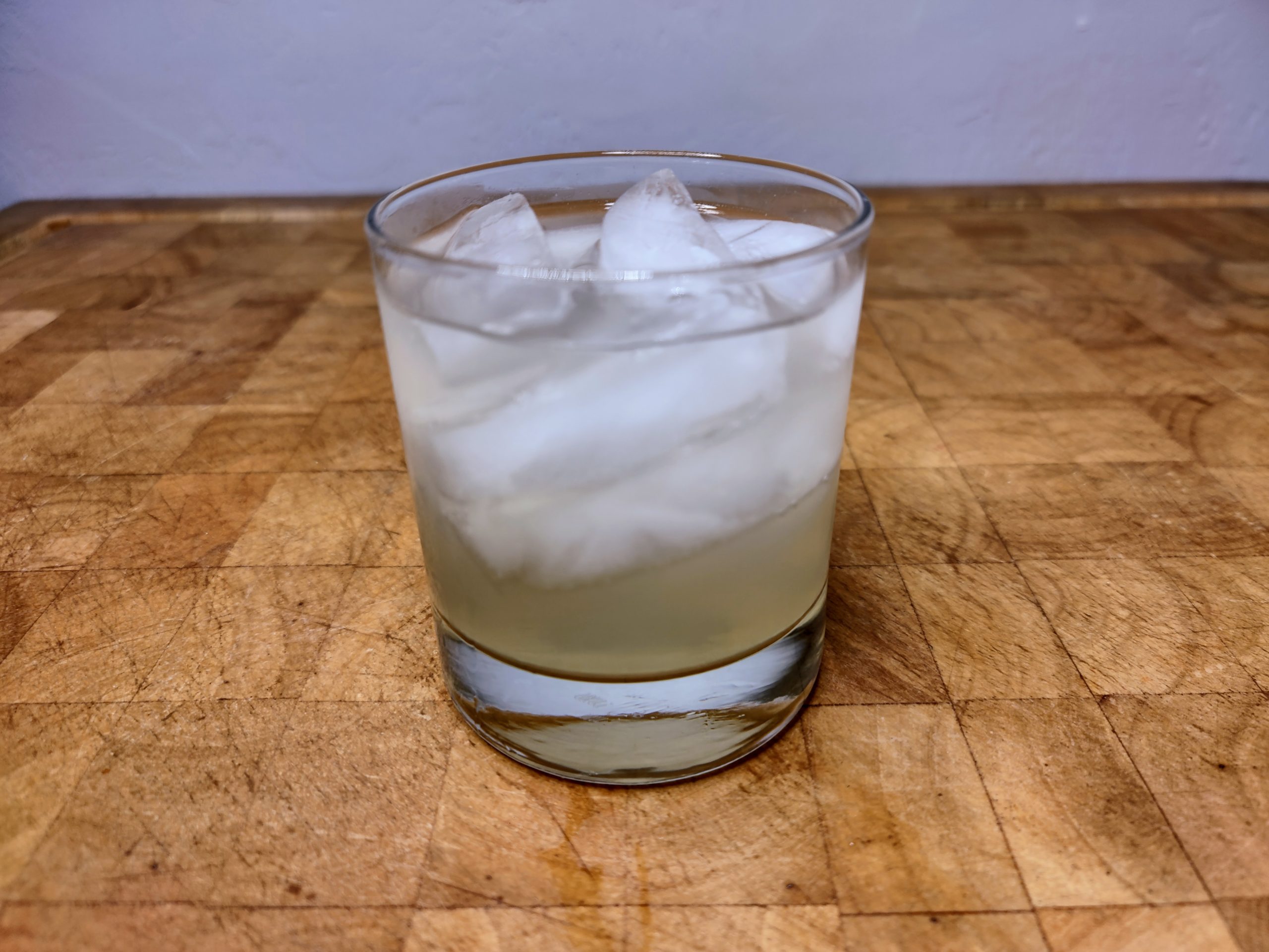 Foghorn drink in a rocks glass on a wooden table.
