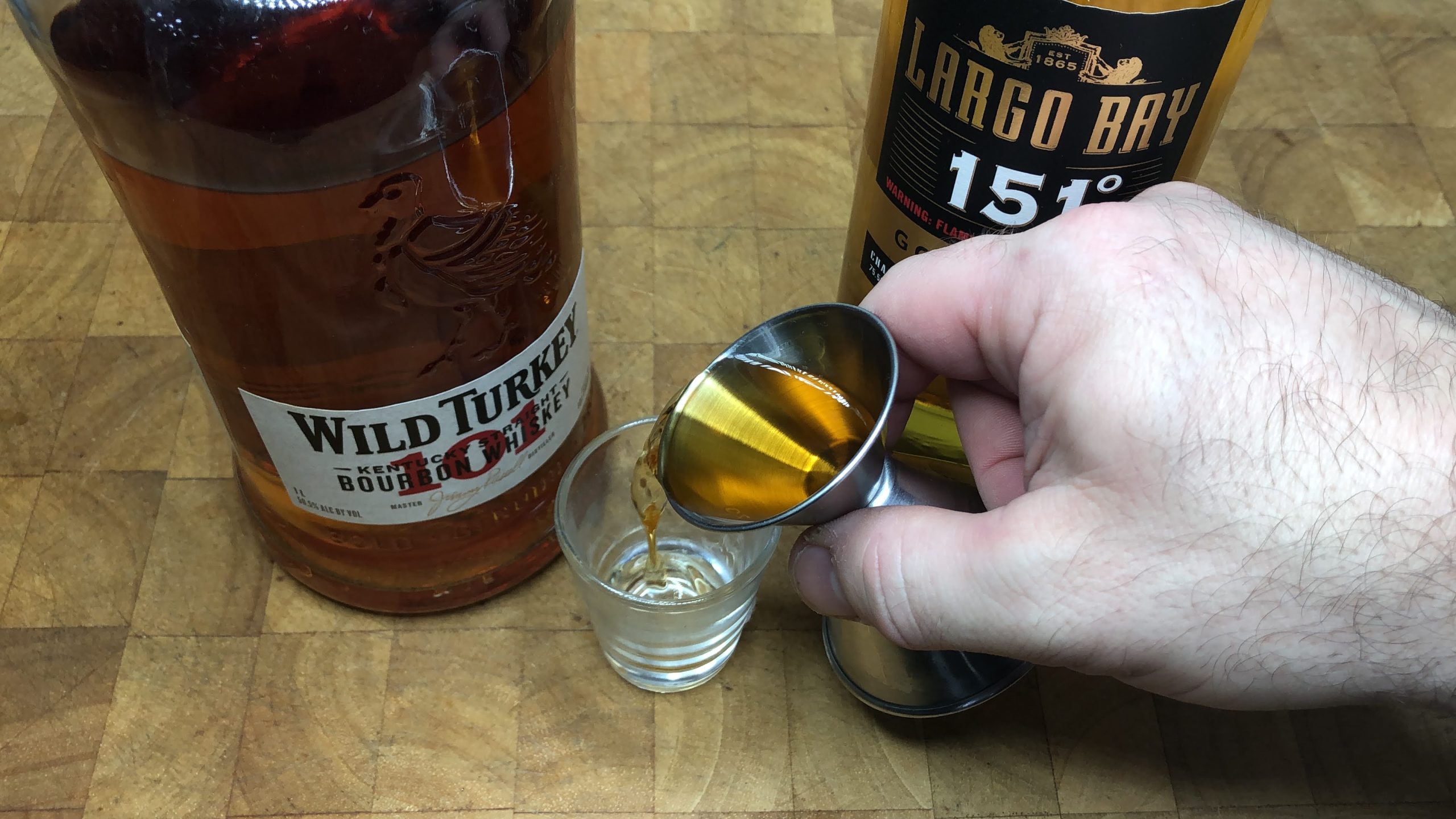 Pouring wild turkey into a shot glass.
