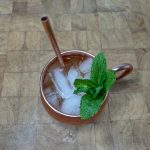 top down view of irish mule in copper mug with a sprig of mint and a copper straw.