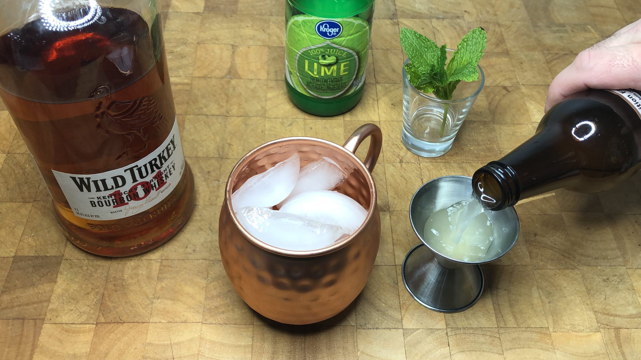 pouring ginger beer in a jigger