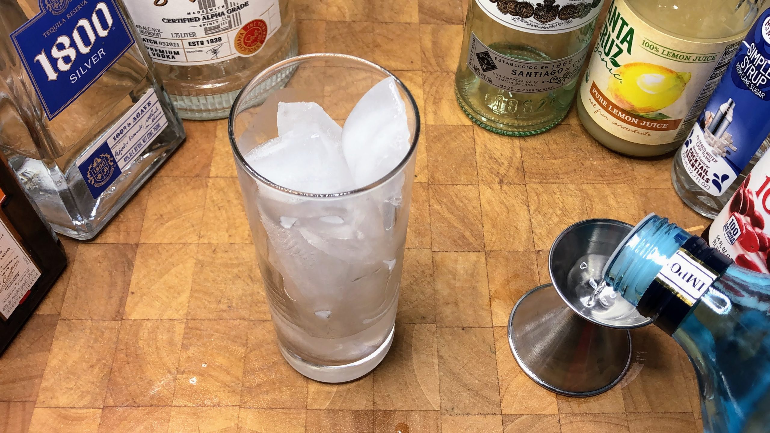 Measuring gin with a jigger.