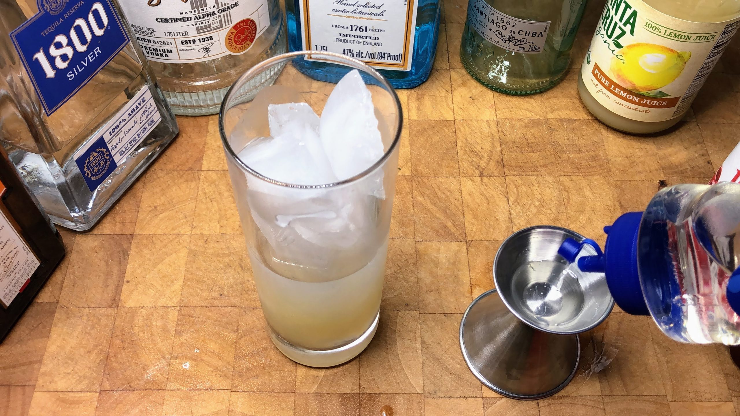Pouring simple syrup into a jigger.