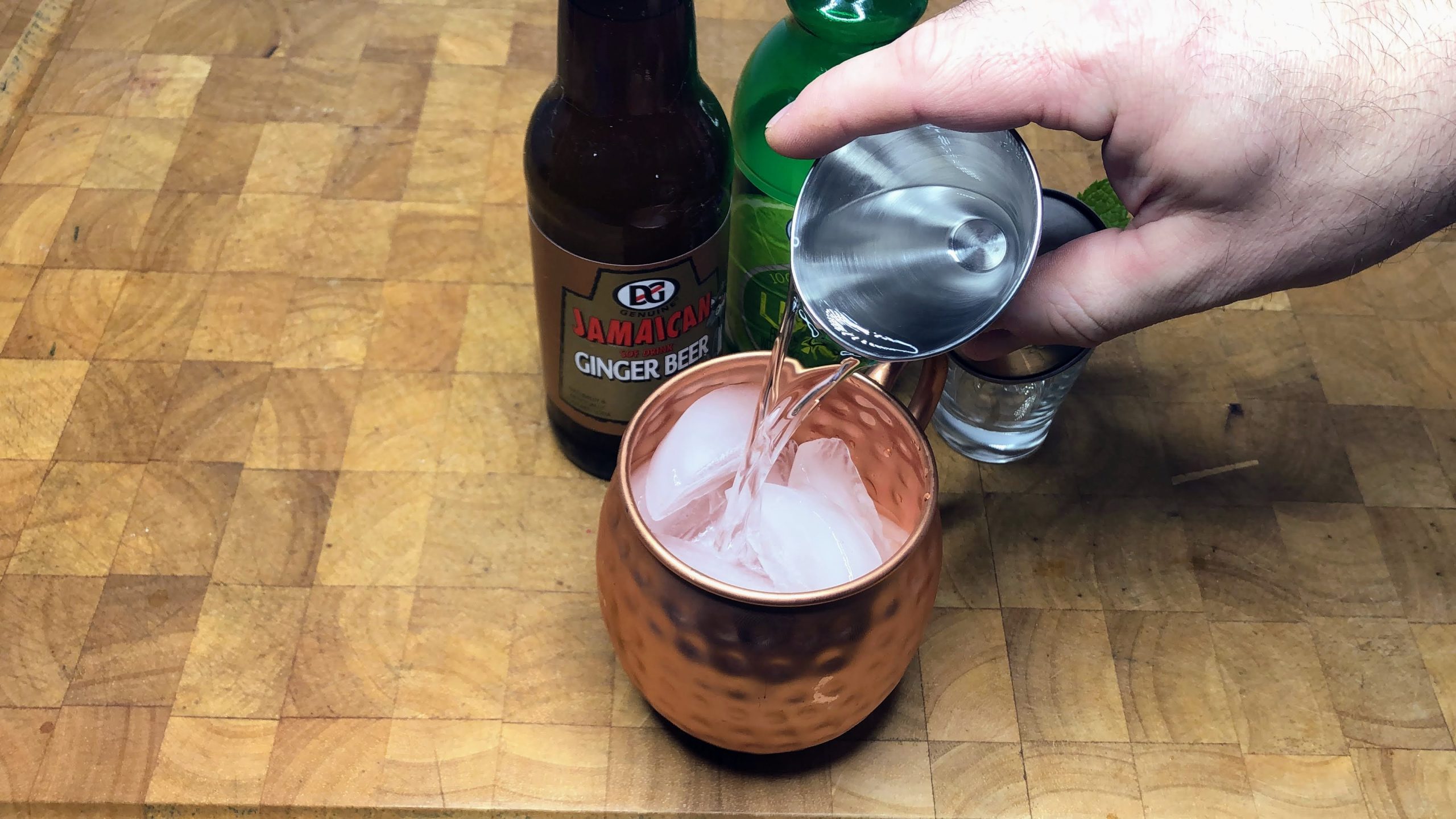 pouring vodka into a copper mug.